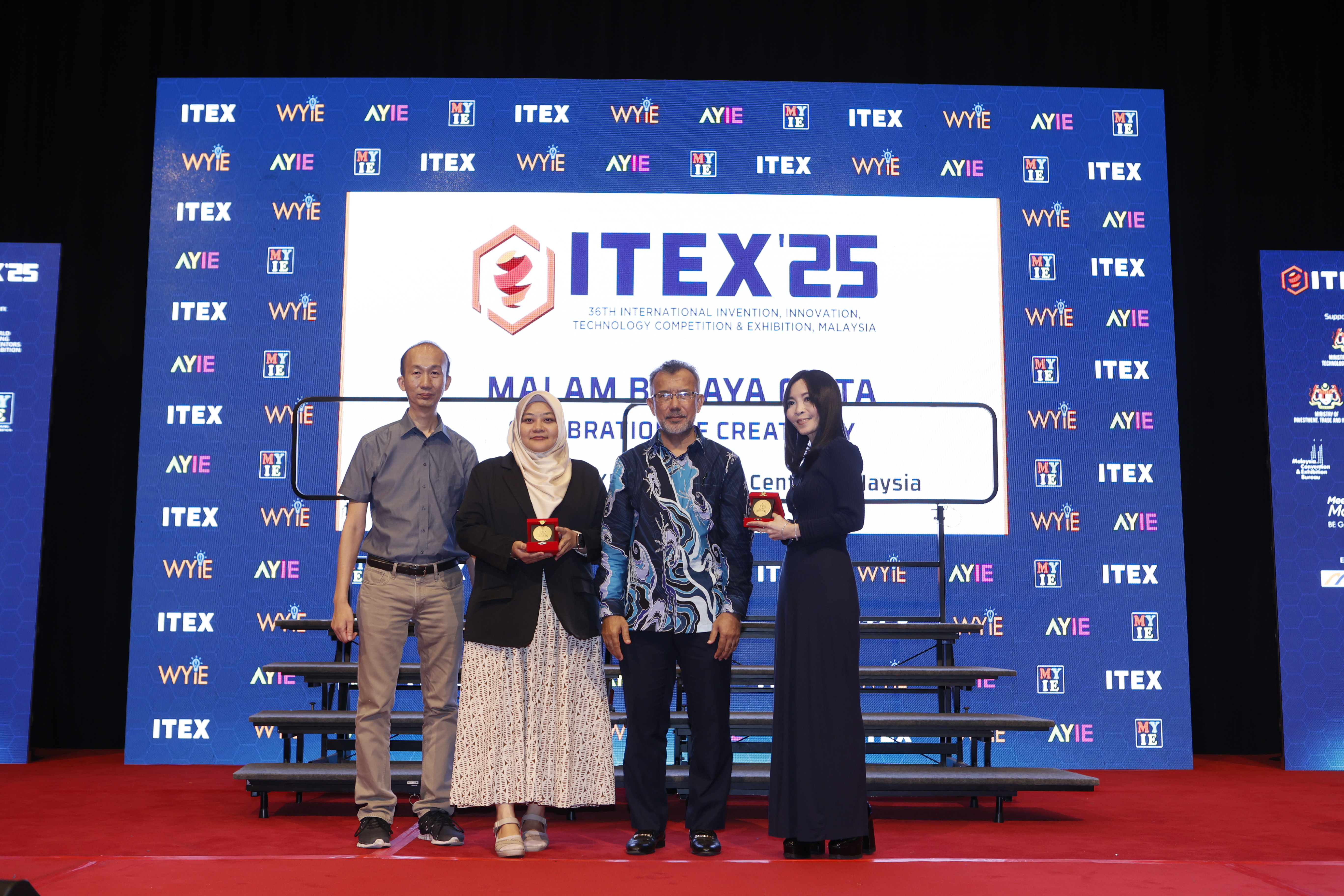 Dr Wong (far right), Dr Jun (far left) and Dr Syahidah (second from left) receiving their medals 