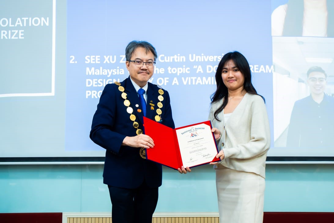 Tey Shu Qi (right) receiving the award