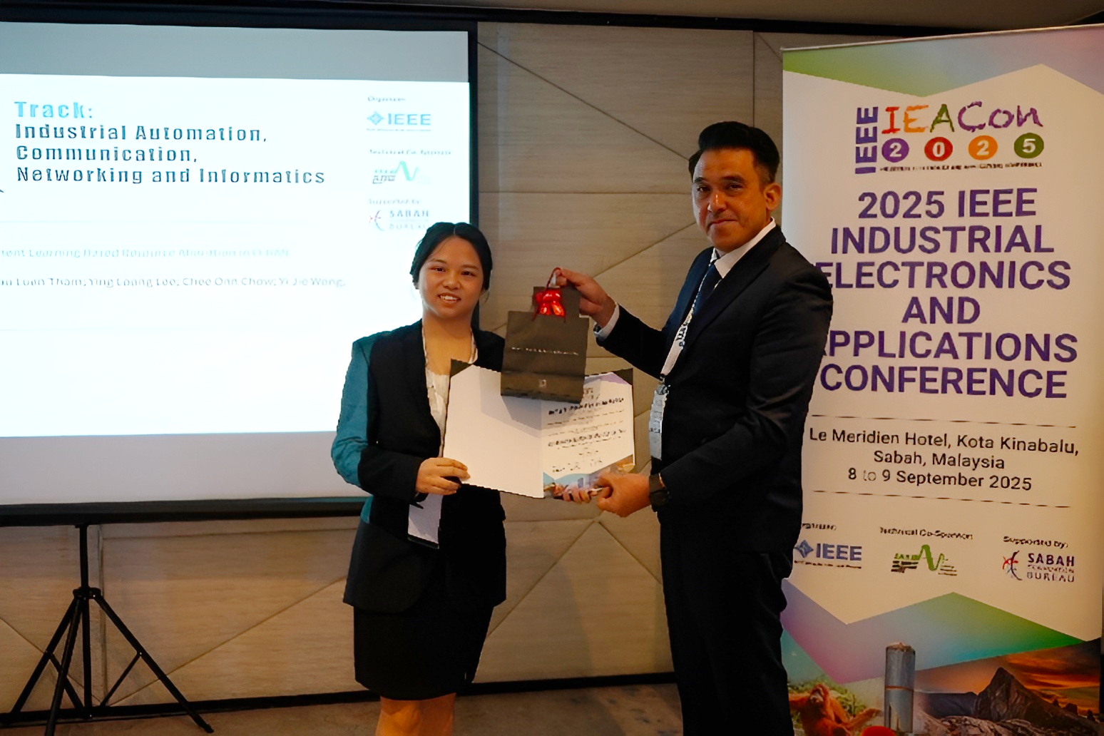 Tan Xin Yi (left) receiving the Best Paper Award at IEACon 2025