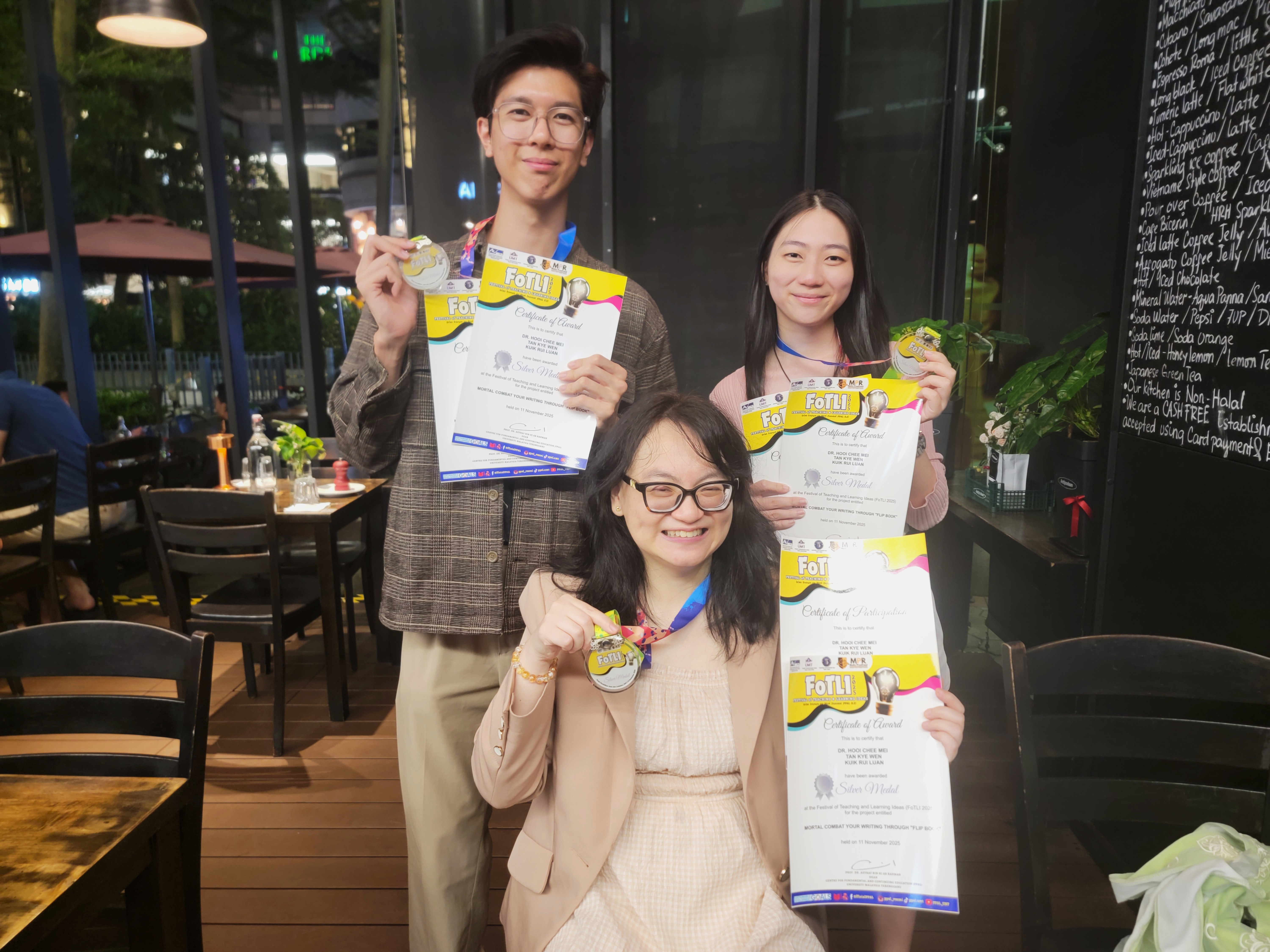 Dr Hooi (front), Tan (back left) and Kuik (back right) with their awards