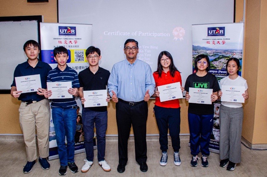 Prof Faidz (middle) presenting a certificate of completion to the students