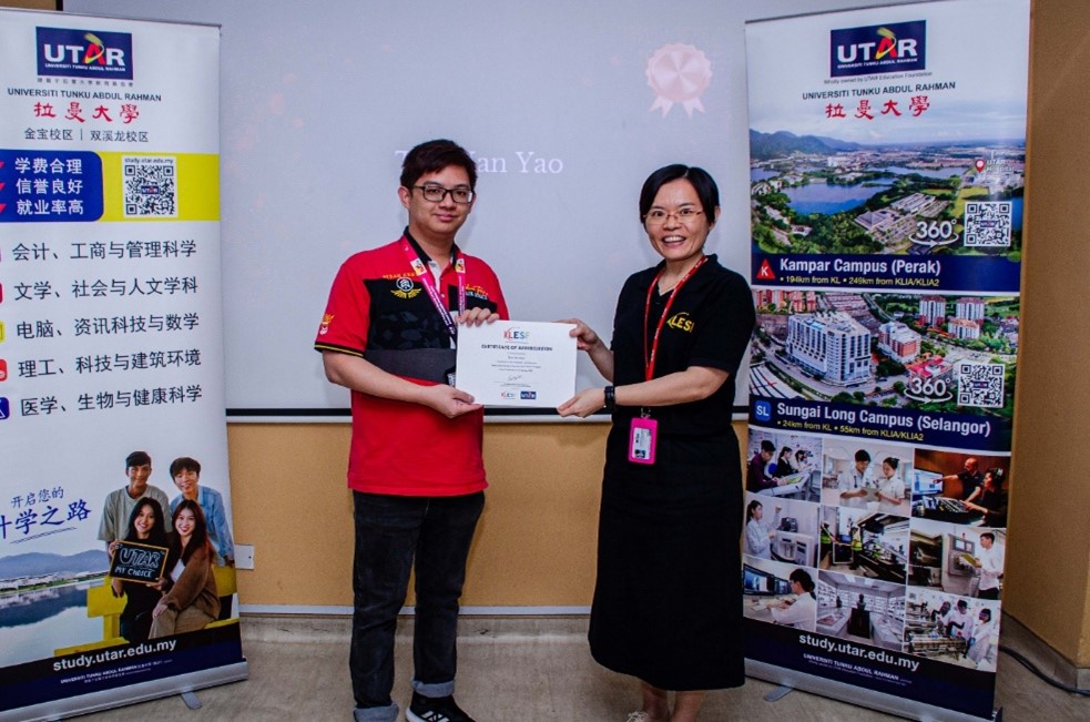 Dr Ong (right) presenting a certificate of appreciation to Teo Han Yao (helpers’ representative)