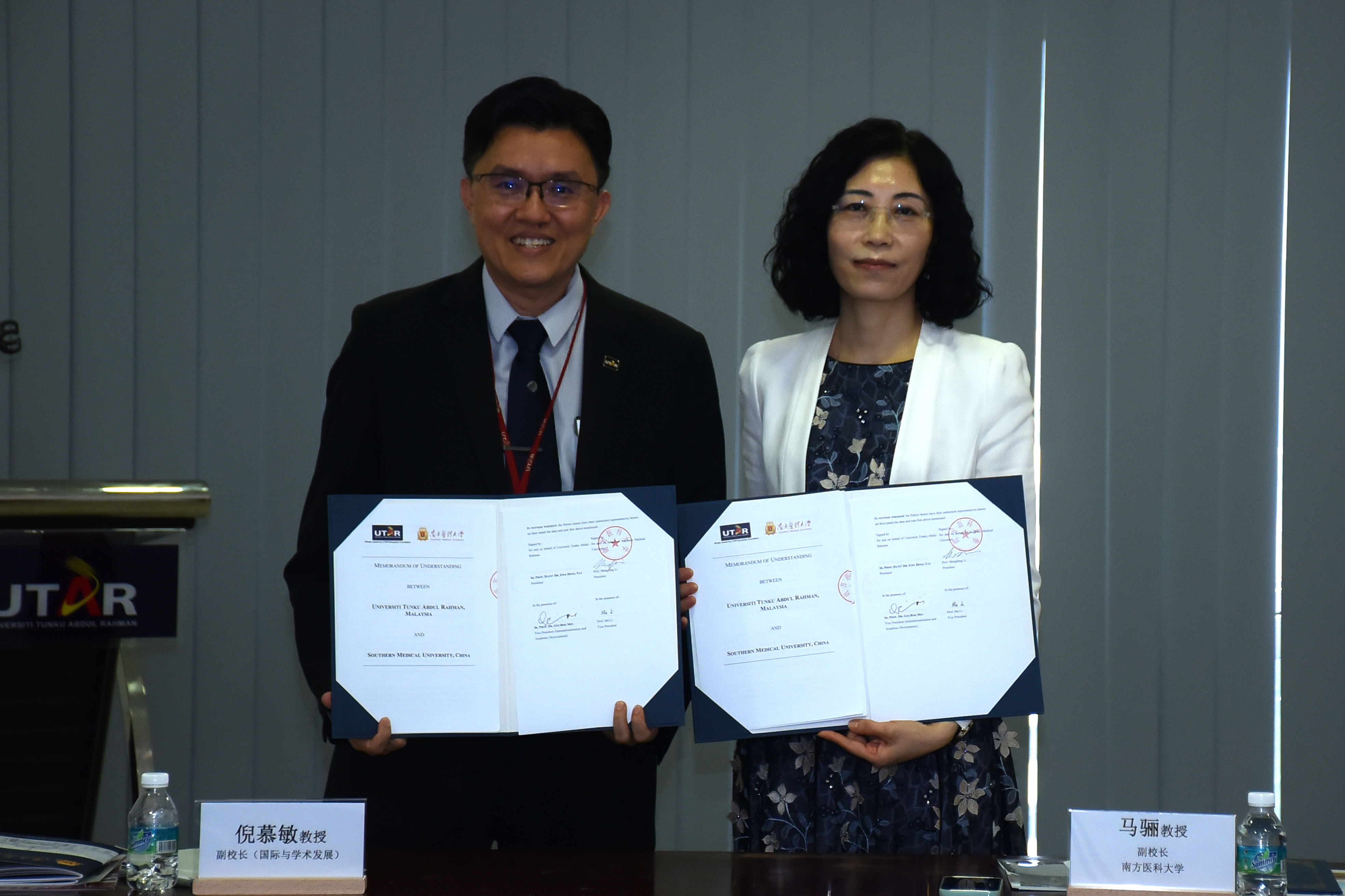 Prof Goi (left) and Prof Ma displaying the signed documents