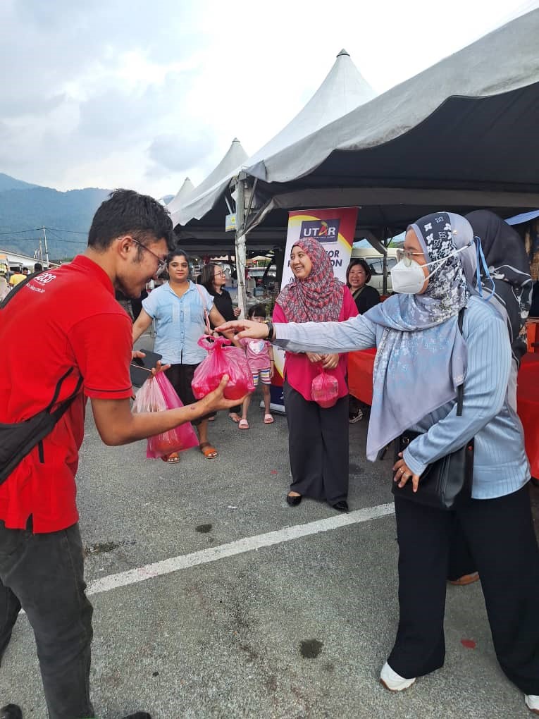 
Team members handing out bubur lambuk to the community