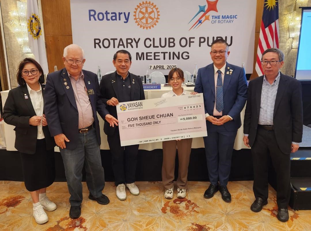 Goh (centre, right) receiving the scholarship from Mr Teoh (centre, left)