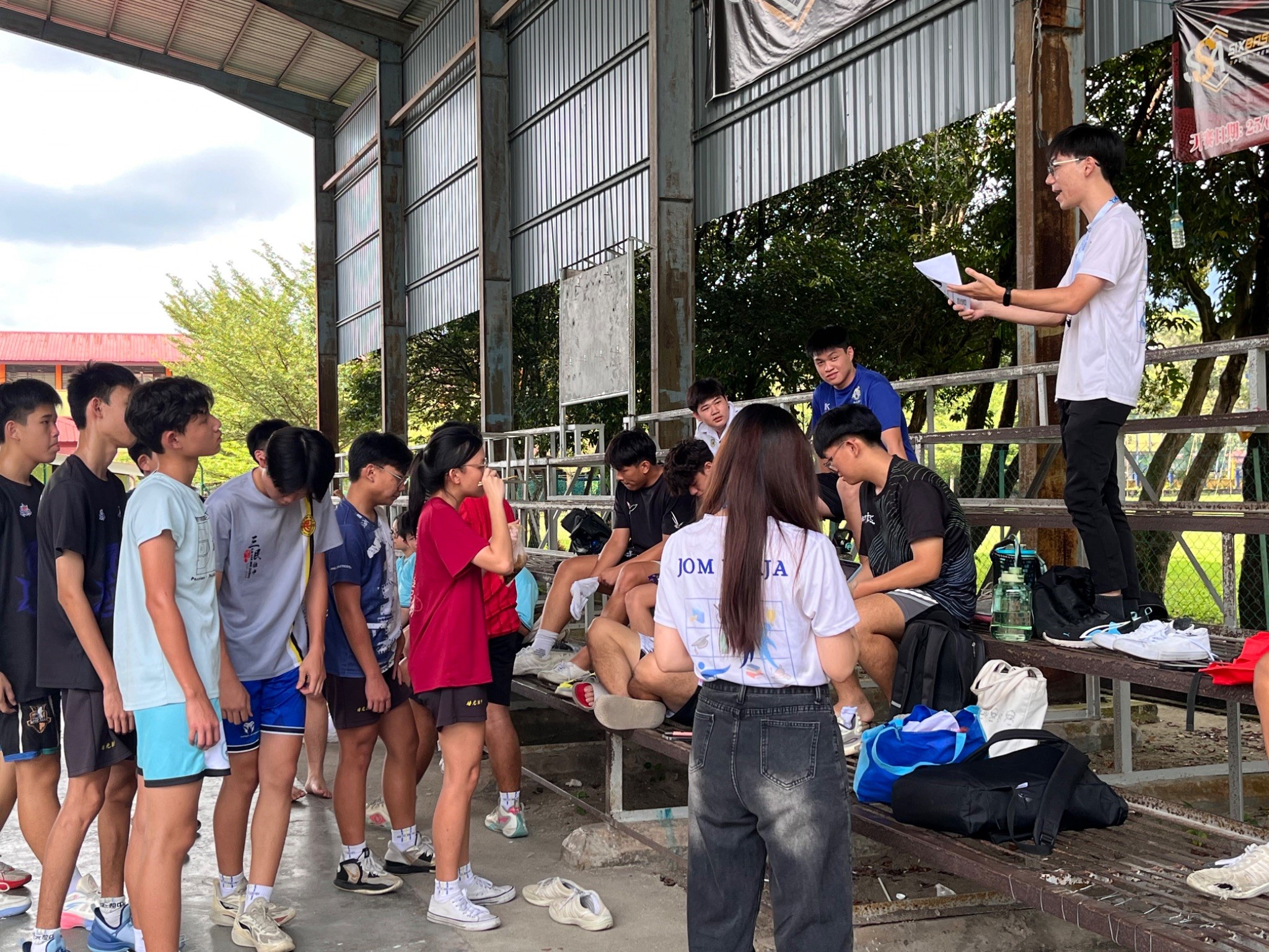 Organising team engaging with secondary school students at the basketball court in Kampar