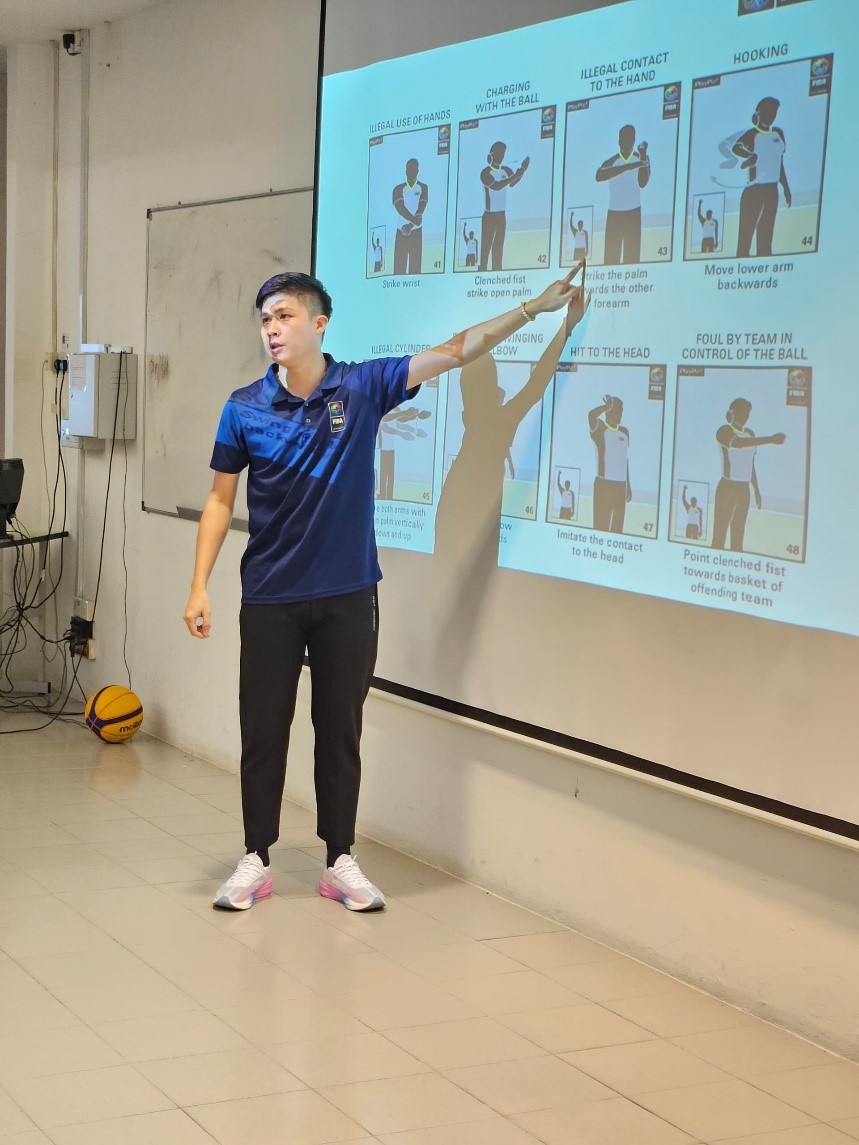 Referee Hum Zhung Liang demonstrating various hand signals used to indicate fouls during the course session