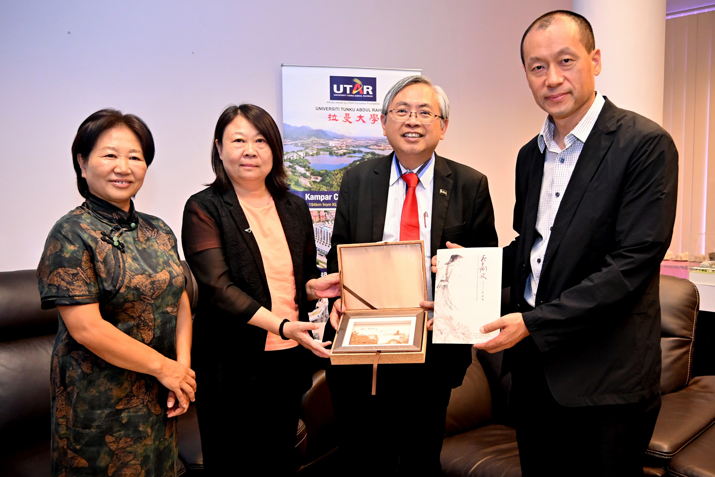 Prof Dato’ Ewe (second from right) receiving commemorative gifts from Ms Han and Prof Liu, with Prof Ma (far left) witnessing the exchange