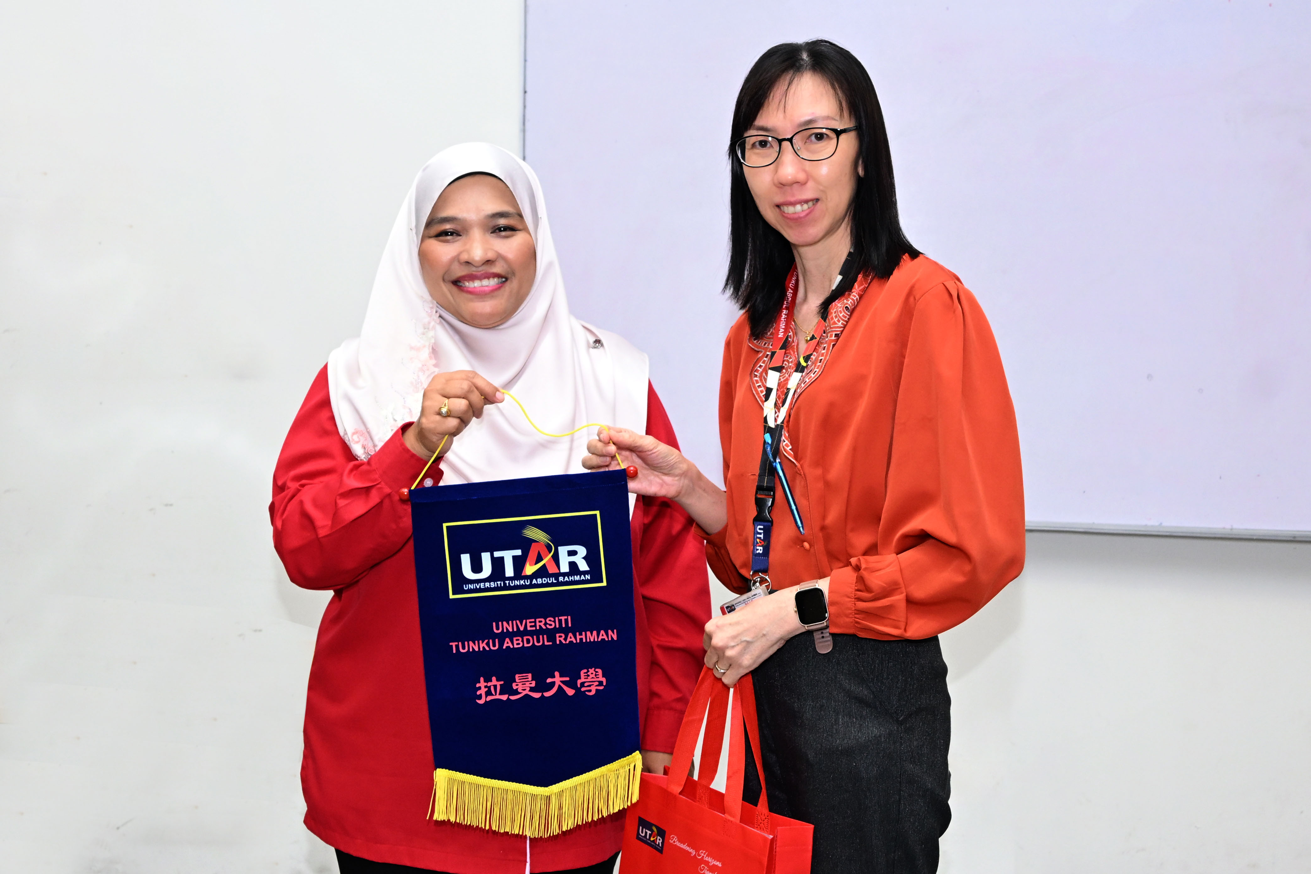 Chairperson of CENTS Dr Low Mei Peng (right) presenting a token of appreciation to Ms Fadhlina (left)