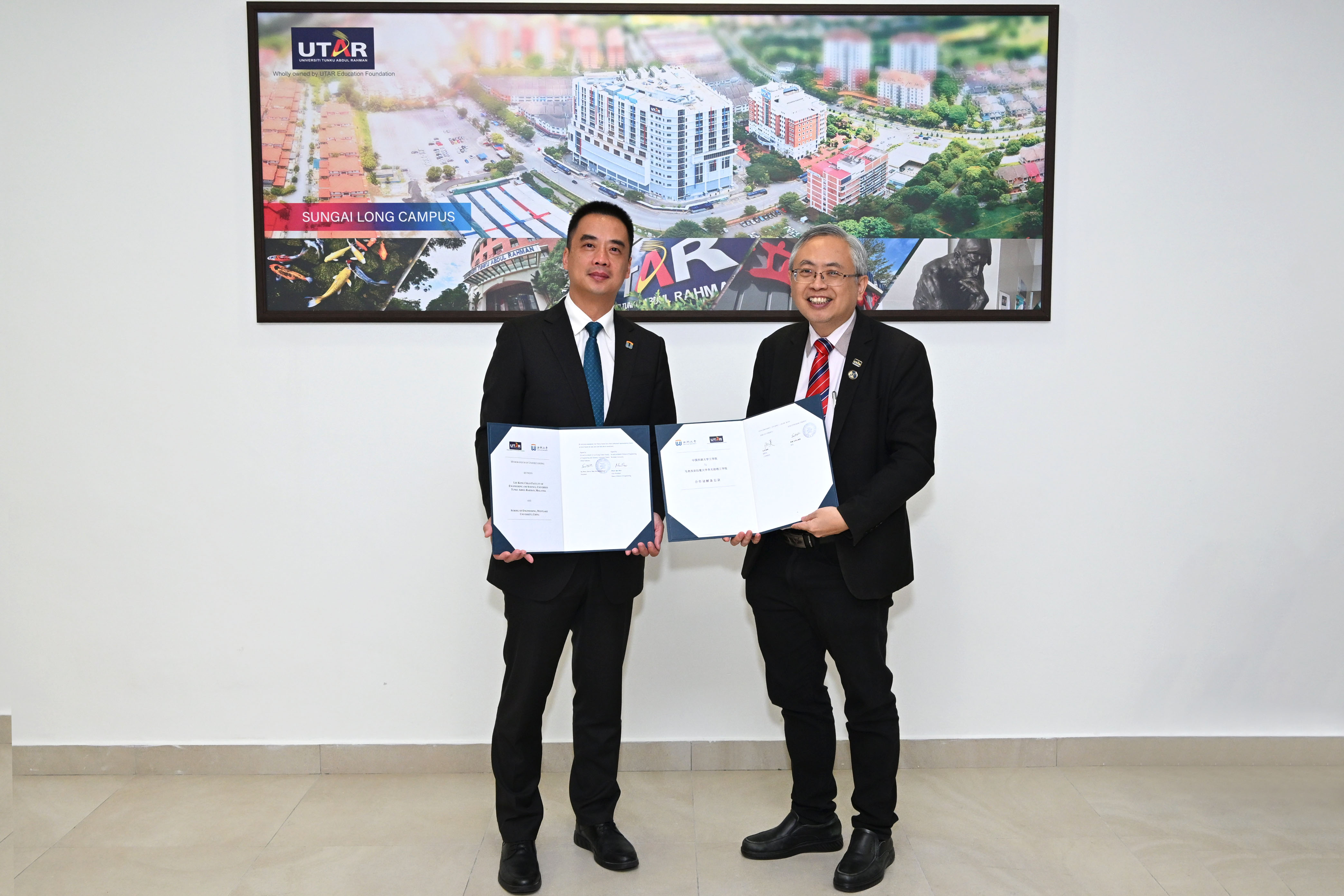 Prof Dato’ Ewe (right) and Prof Qiu displaying the signed document