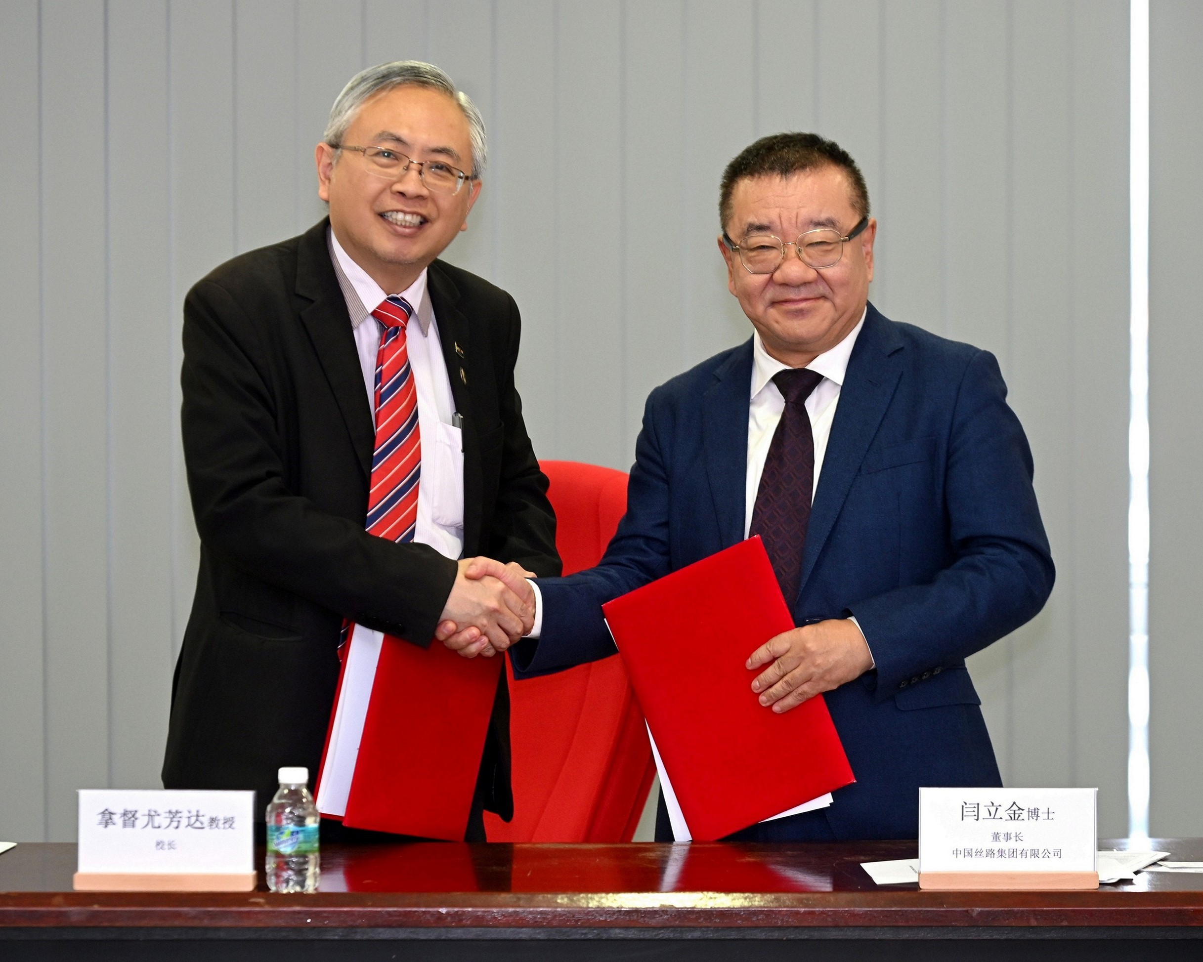Prof Dato’ Ewe (left) and Dr Yan exchanging the MoU documents