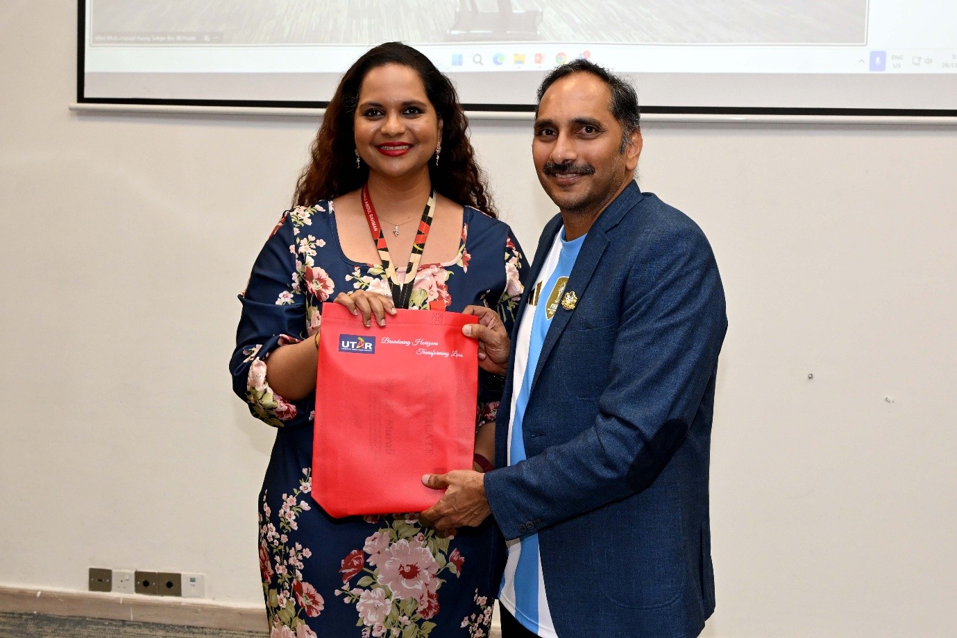 Ms Melissa presenting a souvenir to Mr Murali