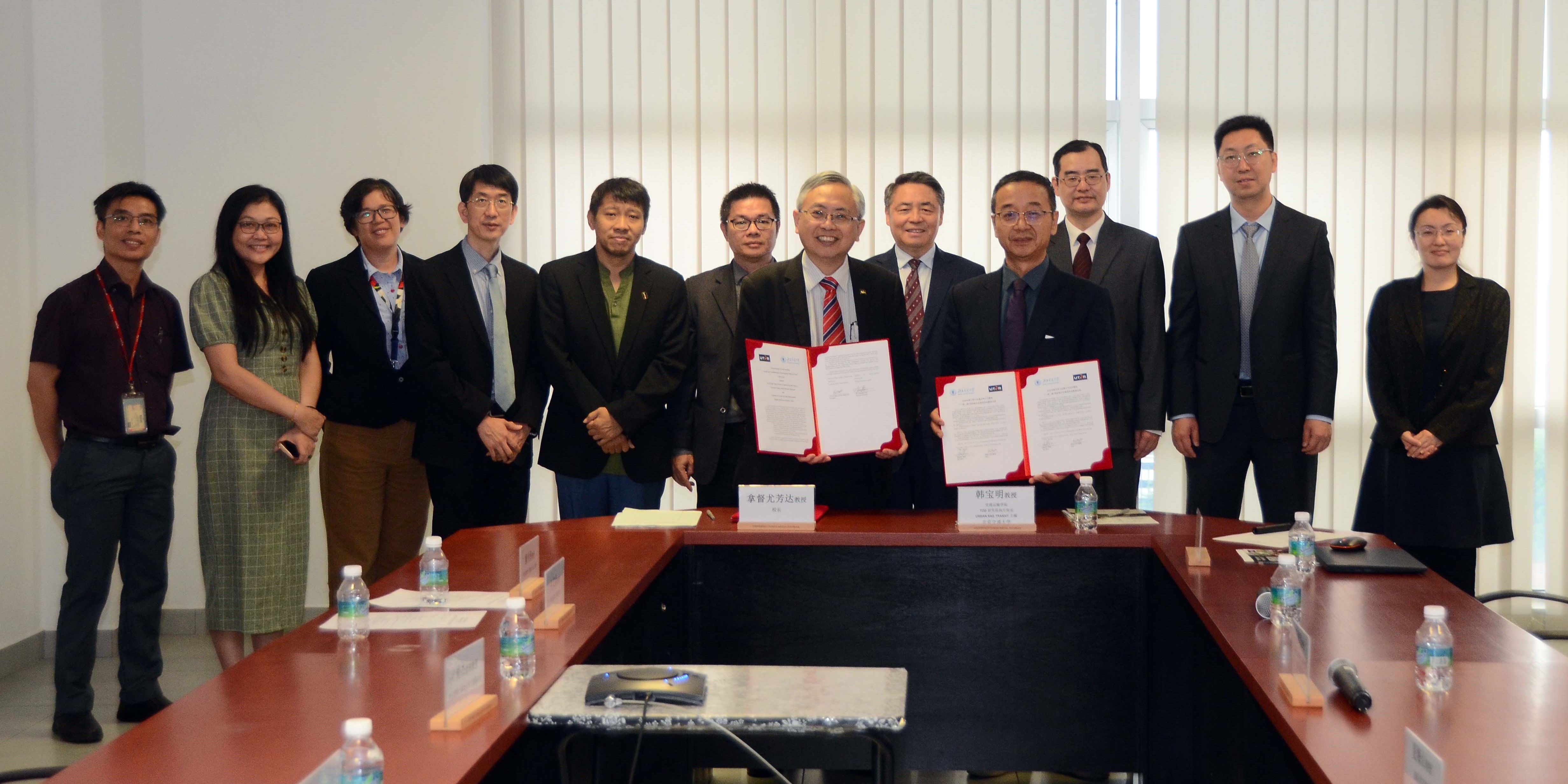 Prof Dato’ Ewe (sixth from right) and Prof Han (fourth from right) exchanging the MoU documents