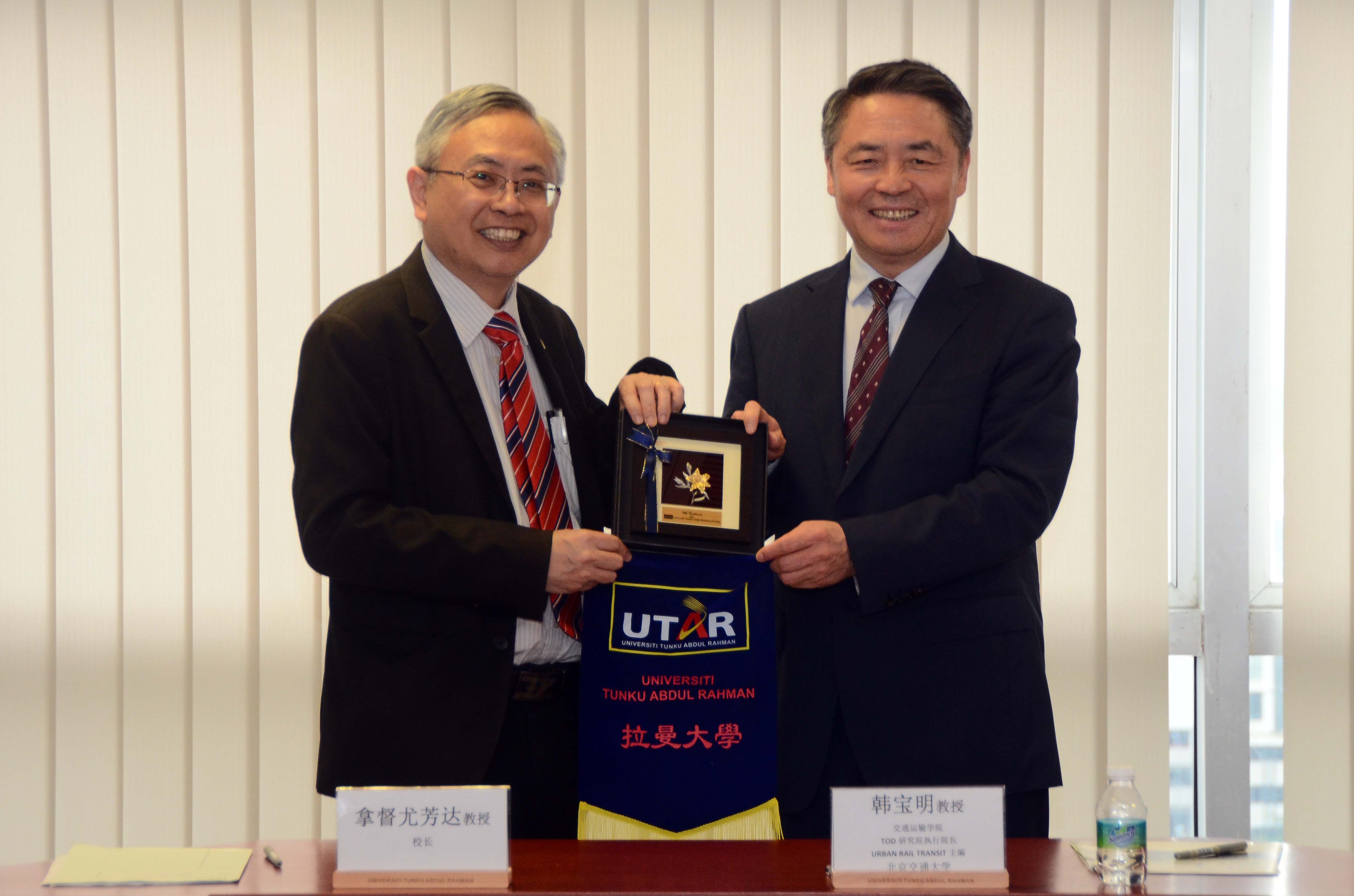 Prof Dato’ Ewe (left) and Prof Wang exchanging souvenirs