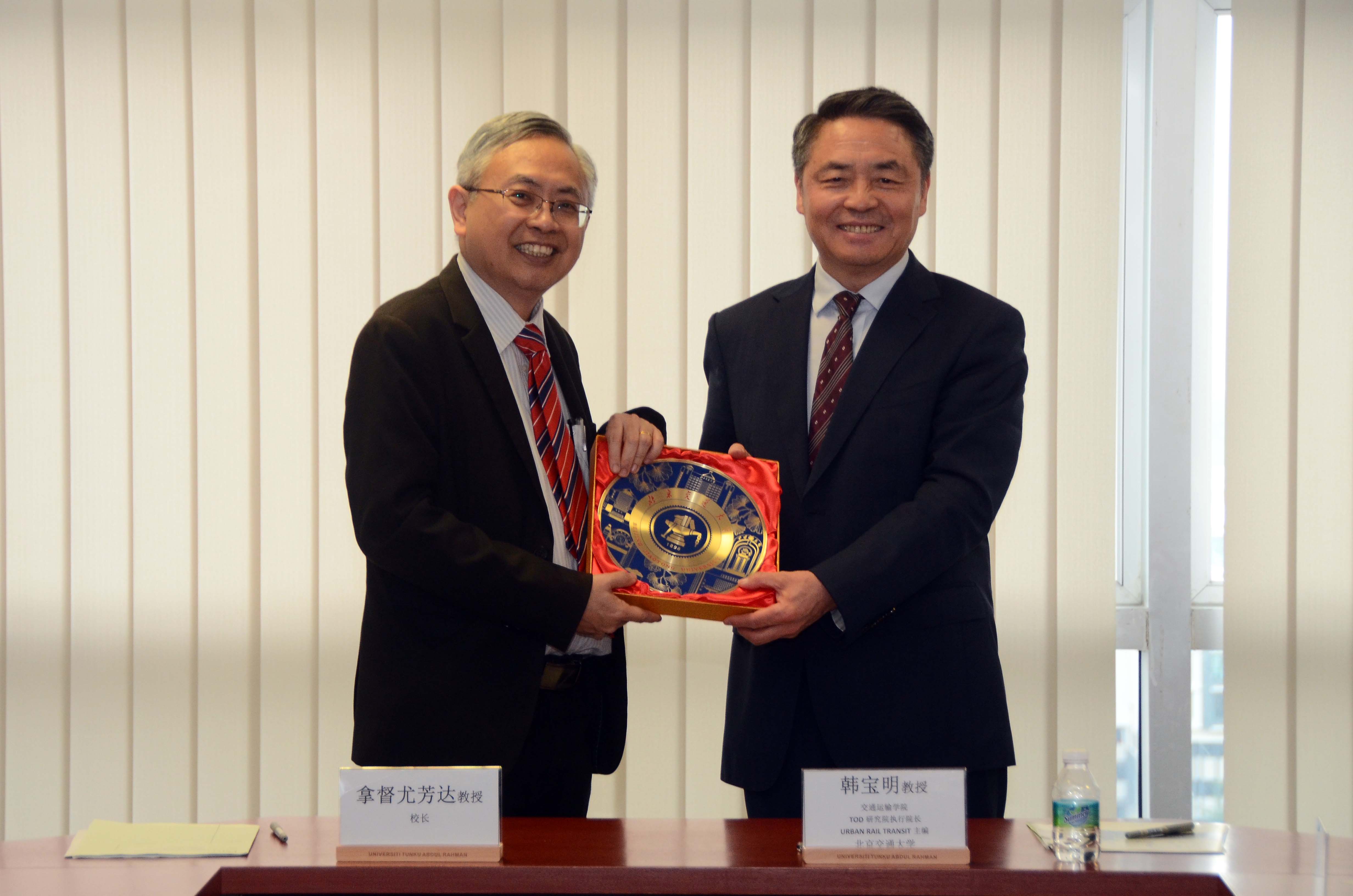 Prof Dato’ Ewe (left) and Prof Wang exchanging souvenirs