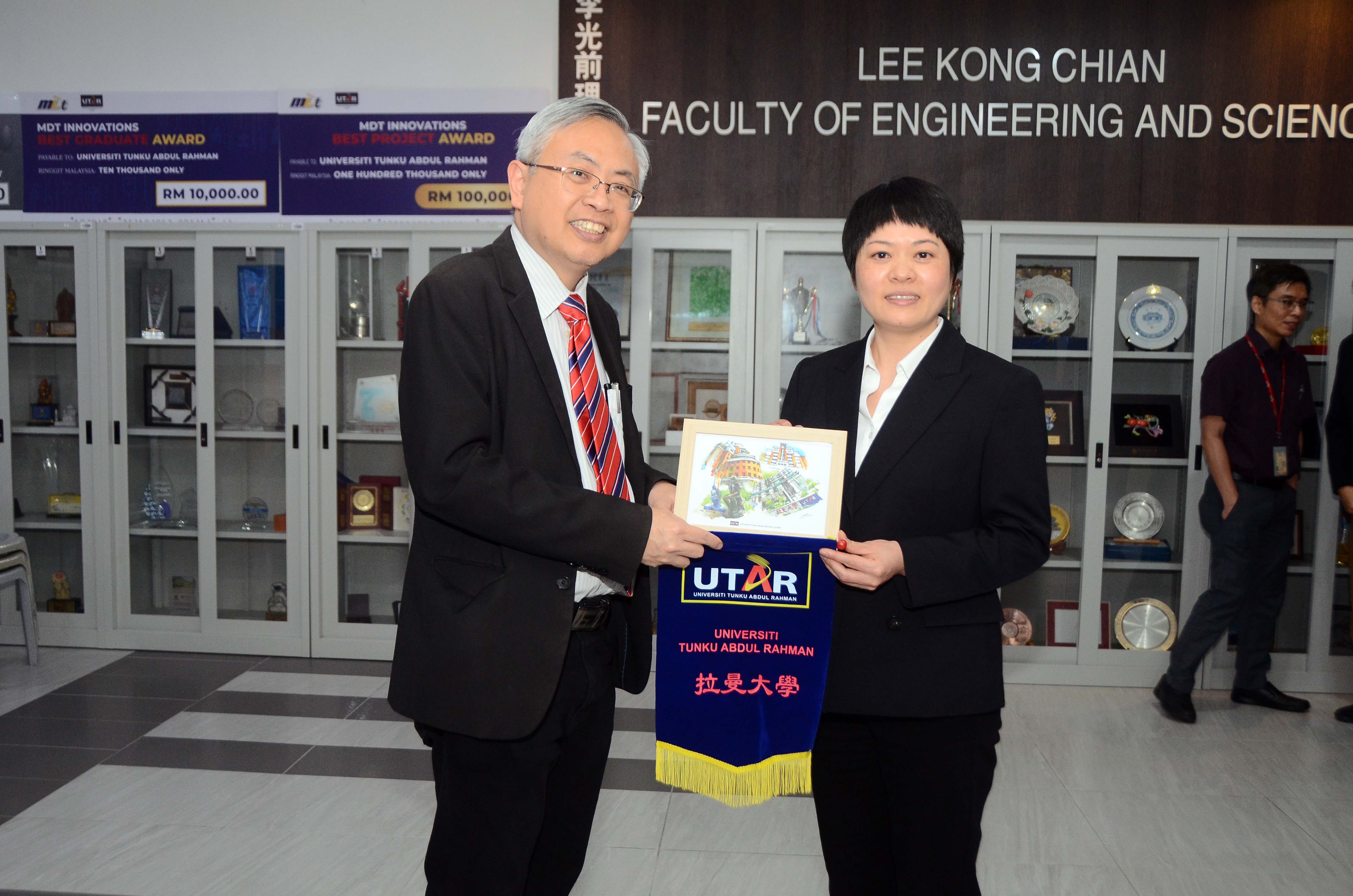 Prof Dato’ Ewe (left) and Ms Wang exchanging souvenirs