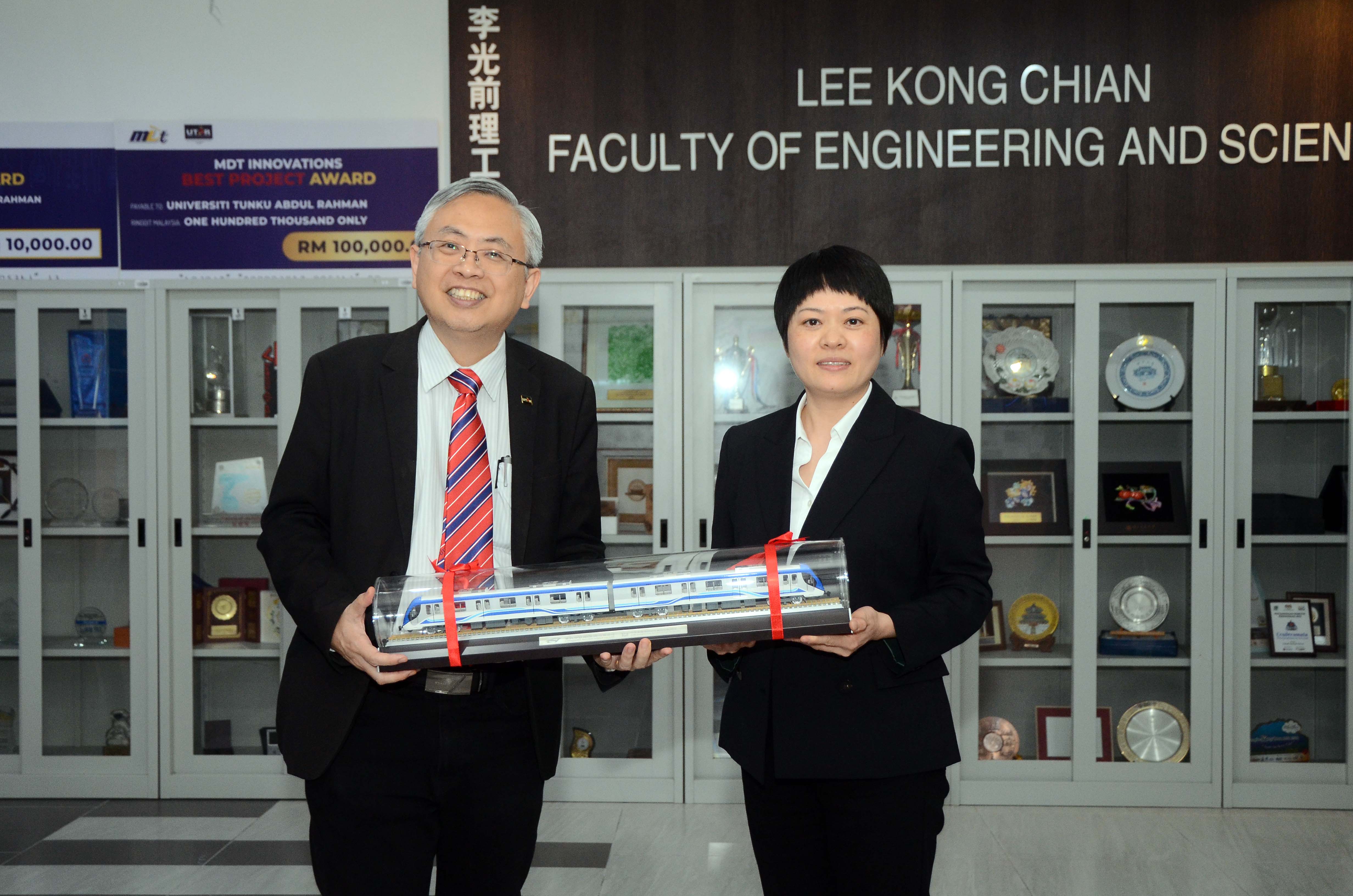 Prof Dato’ Ewe (left) and Ms Wang exchanging souvenirs