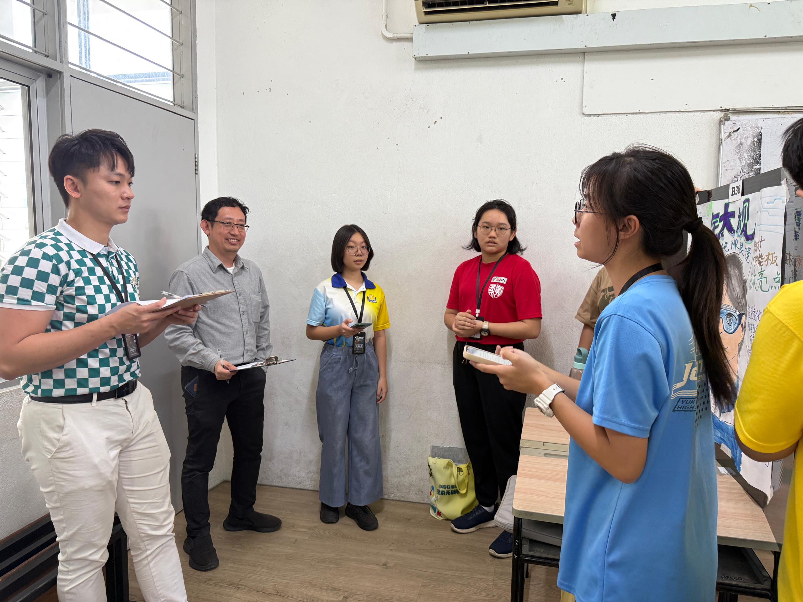 Dr Lee and Dr Lam evaluating student posters during the science poster competition