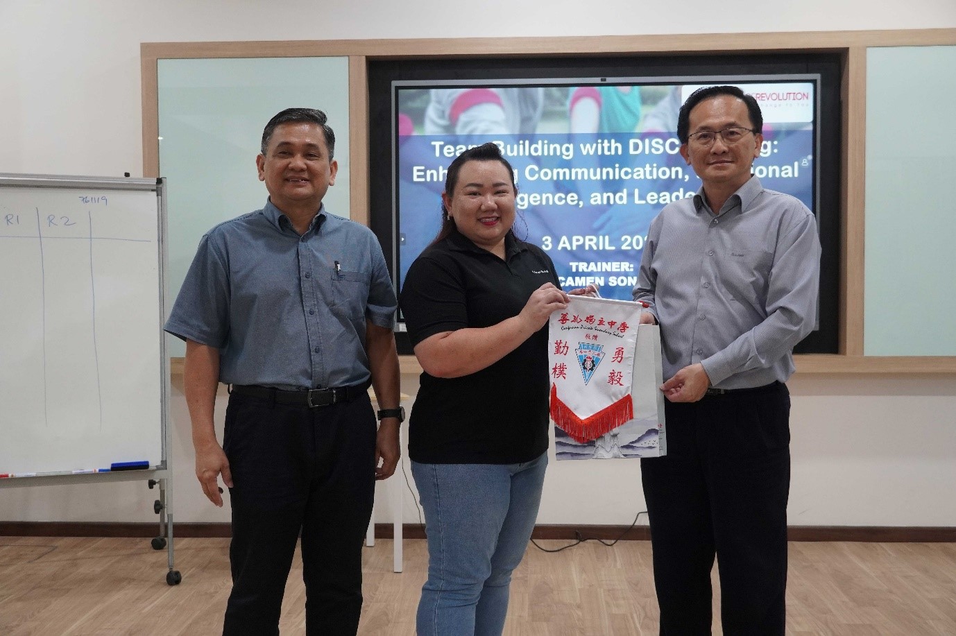 Ms Song (centre) receiving tokens of appreciation from Mr Goh (far right)