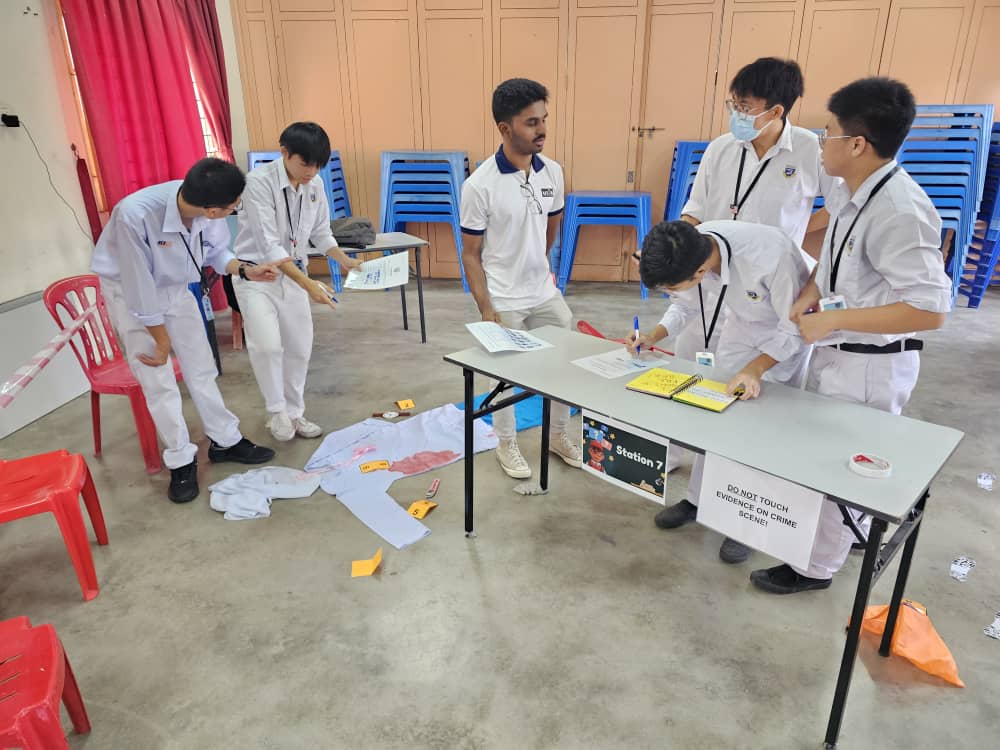 Students confidently tackling crime scene clues at Station 7, demonstrating detective skills beyond their years
