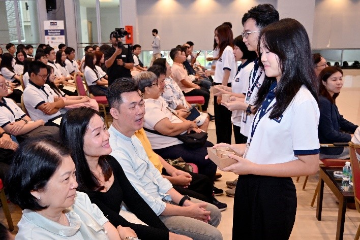 Recipients serving tea to their parents as gratitude for their unwavering support