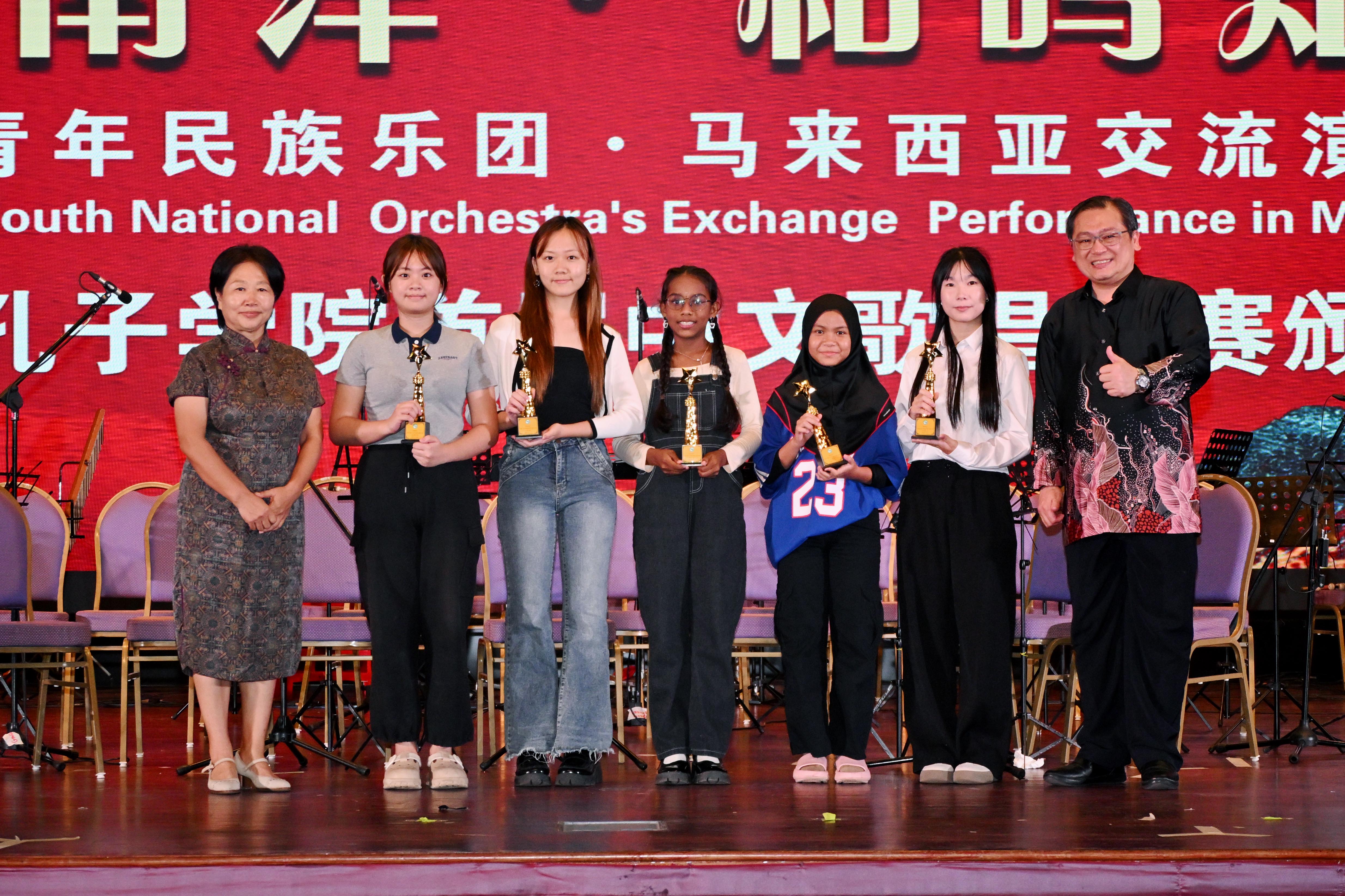Prof Ma Yingxin (far left) and Dr Chong (far right) with the winners of the Chinese Singing Competition