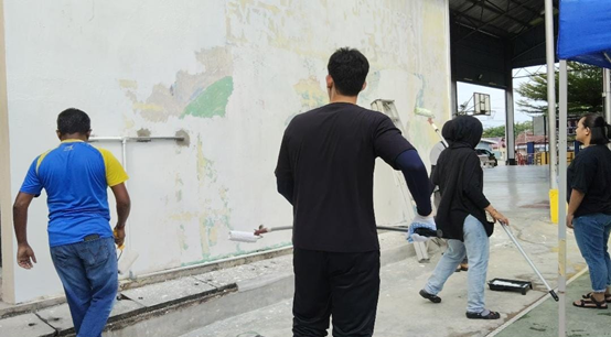 UTAR staff preparing the wall at SMK Methodist ACS Kampar for the mural painting project — the first step in transforming the space into a vibrant canvas of creativity, collaboration, and community spirit