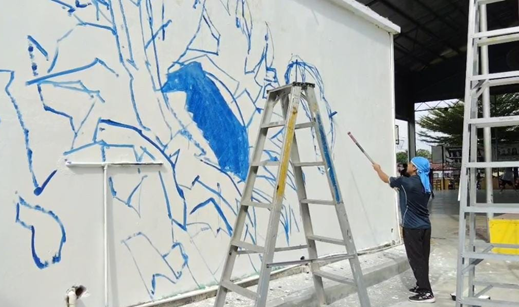 UTAR staff outlining the mural design at SMK Methodist ACS Kampar, bringing the initial sketches to life