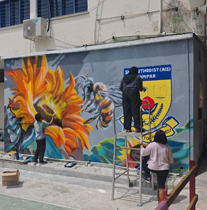 Adding final touches to the mural art at SMK Methodist ACS Kampar