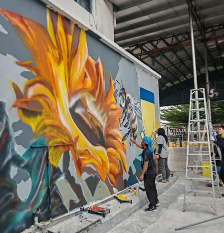 UTAR staff adding the final touches to bring the sunflower and bee mural to life 