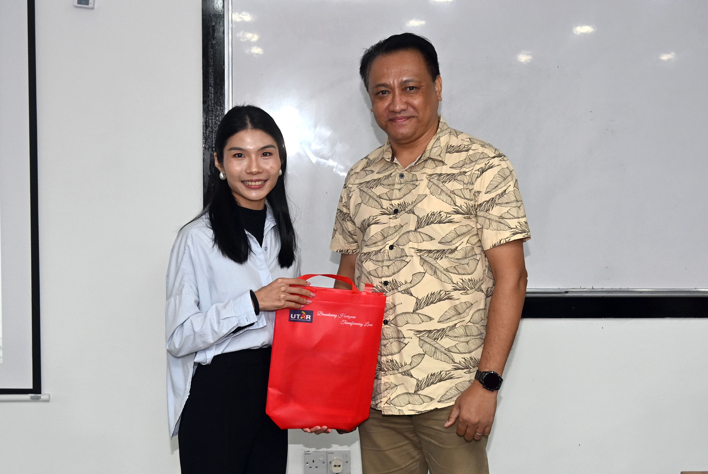 CFS-SL academic Mr Robert Walter Benjamin Christian (right) presenting a token of appreciation to Ms Lim