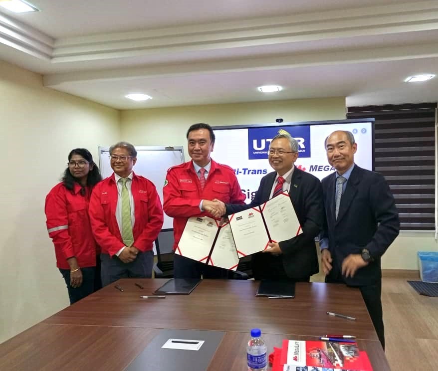 Mr Adrian Tan (third from left) exchanging the signed MoU with Prof Dato’ Ewe, witnessed by Dr Lim, (far left) Ms Letchimy and En Hasni