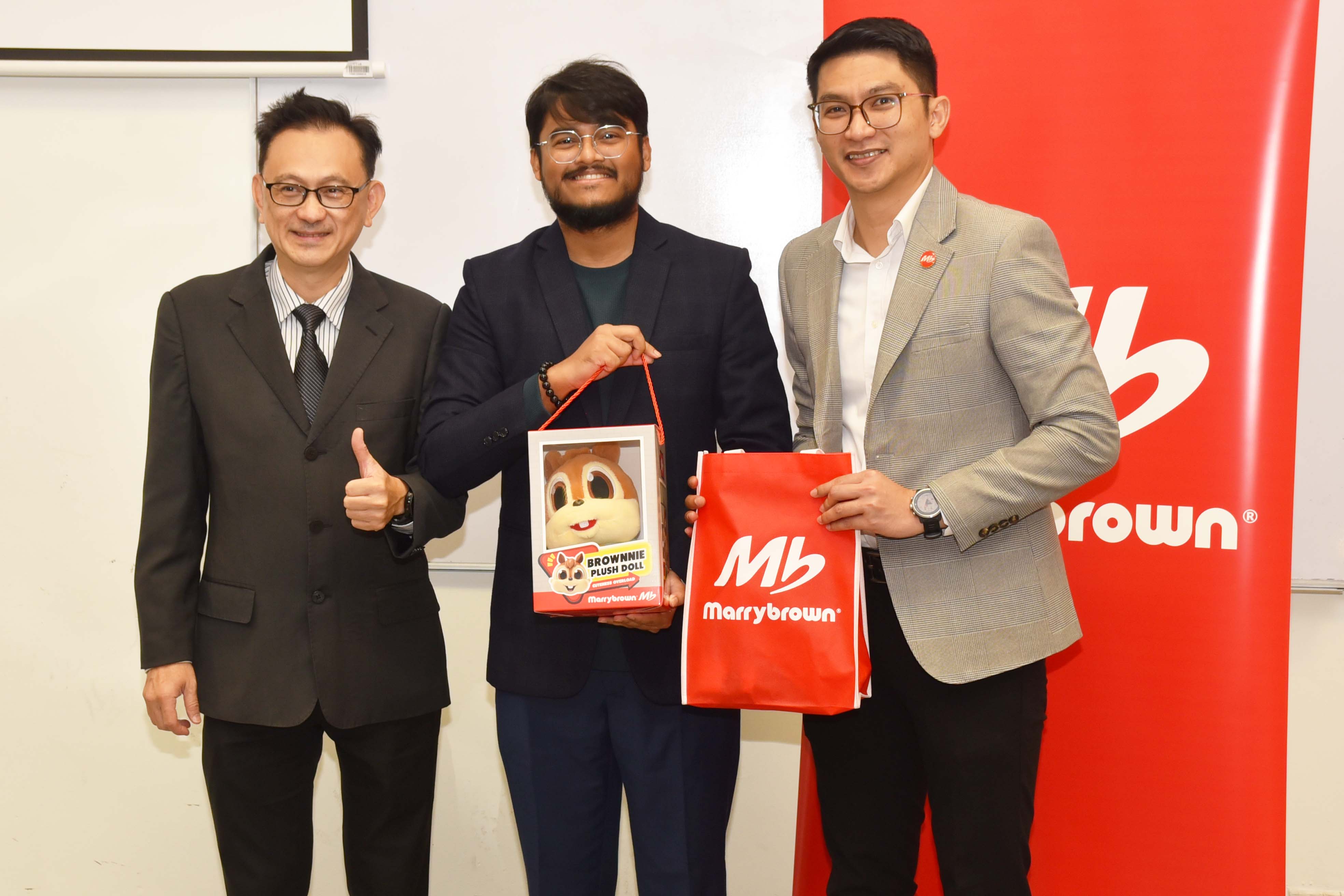 Mr Daniel Chan (far left) presenting a token of appreciation to Marrybrown Training Manager Mr Balachanthren Sinna Nair