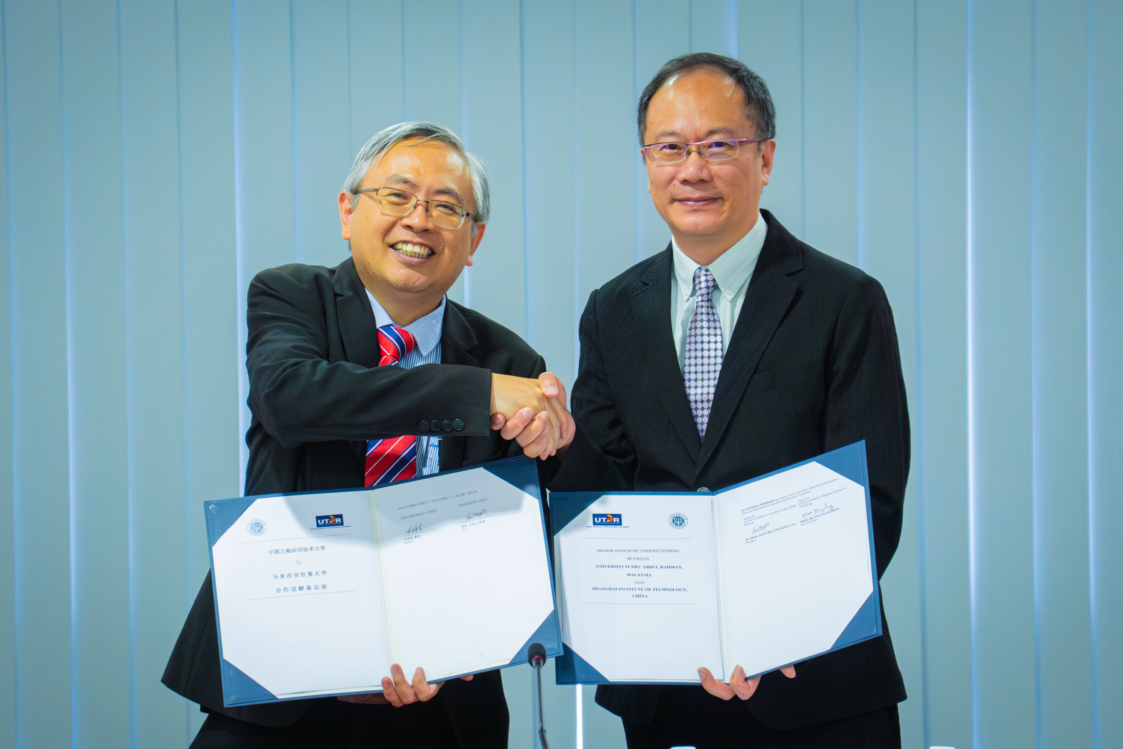 Prof Dato’ Ewe (left) and Prof Mao displaying the signed documents