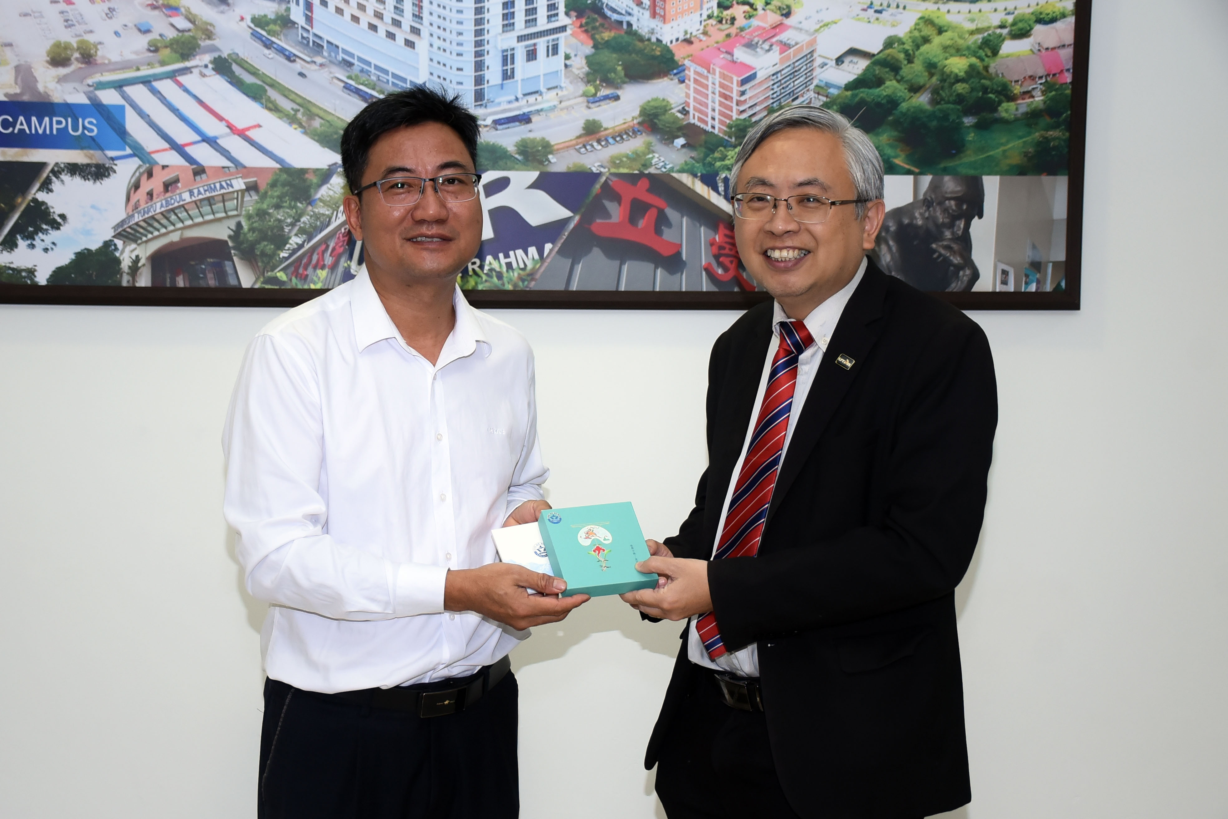 Mr Liang (left) and Prof Dato’ Ewe exchanging souvenirs