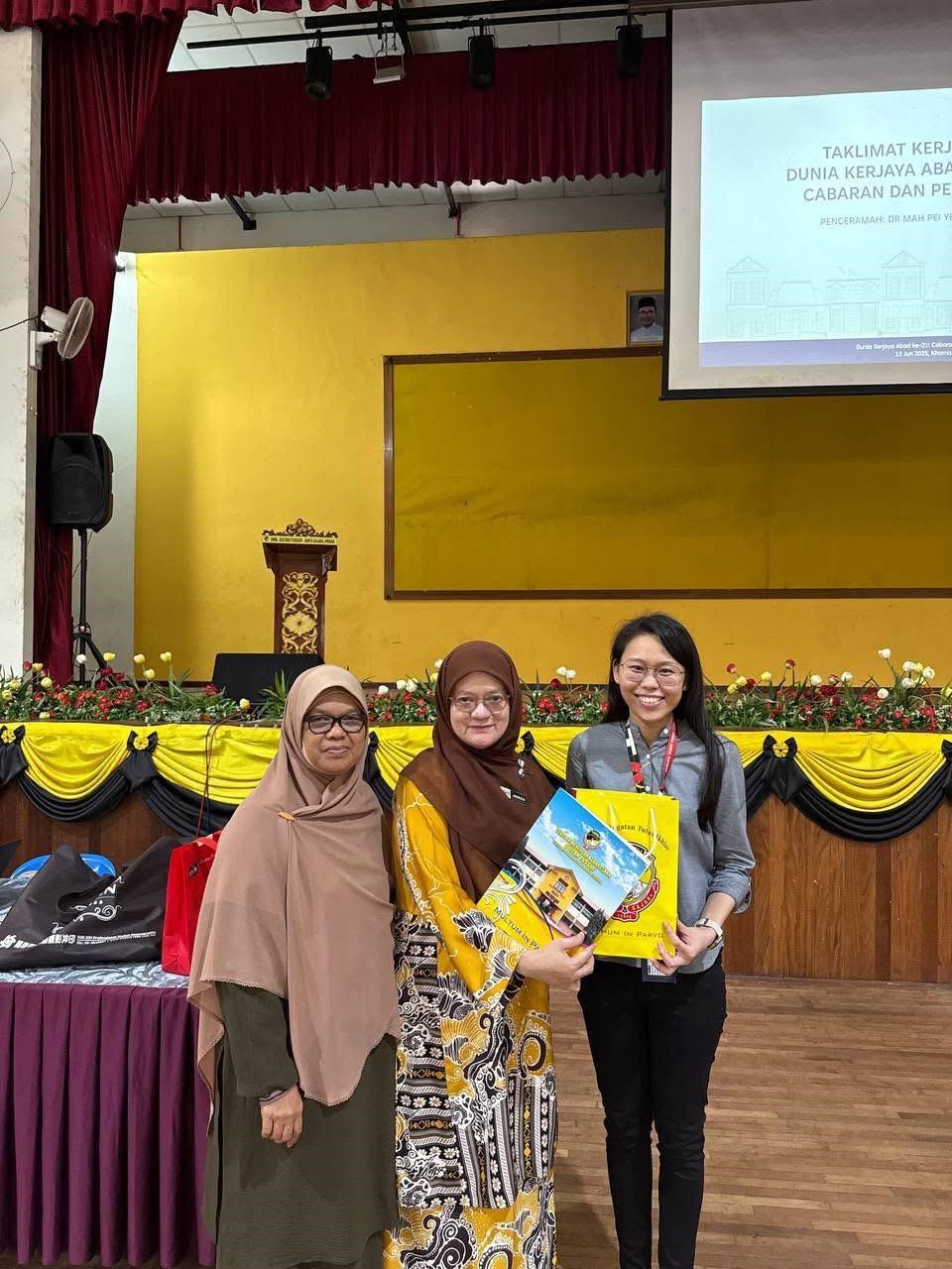 Pn Aenizawati delivering a token of appreciation to Dr Mah