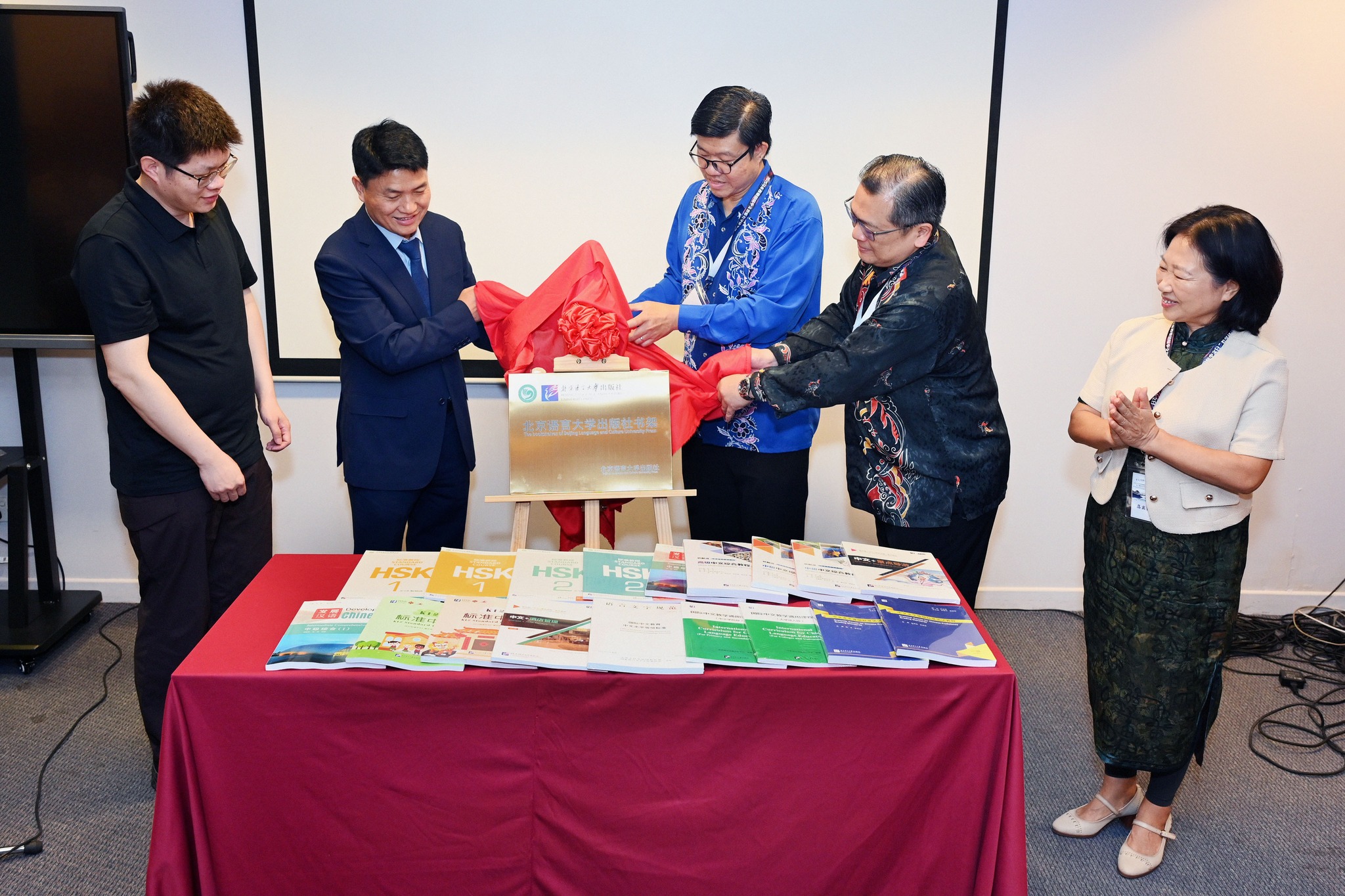 From right: Prof Ma, Dr Chong, Prof Choong and Prof Chen unveiling the plaque of “The bookshelves of Beijing Language and Culture University Press”