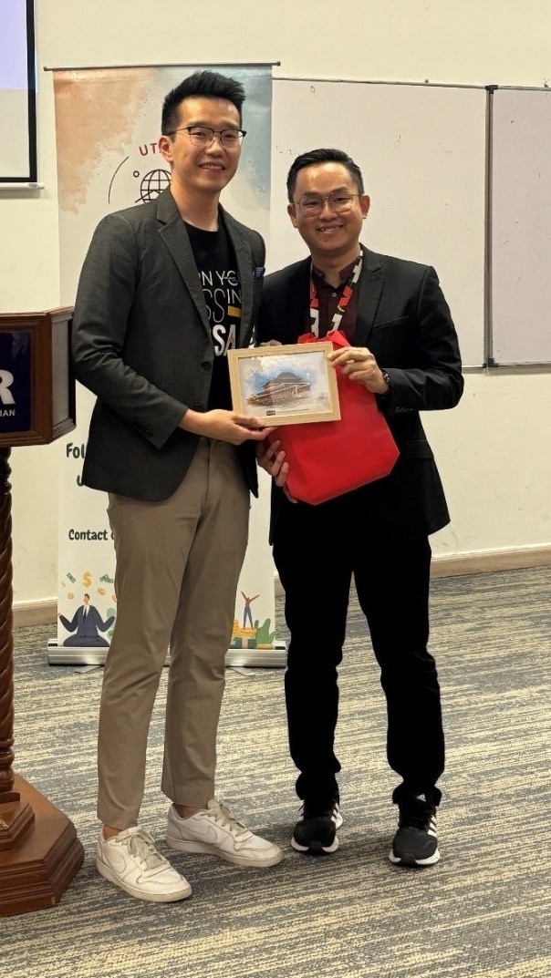 Mr Low presenting a token of appreciation to Mr Tay (left)