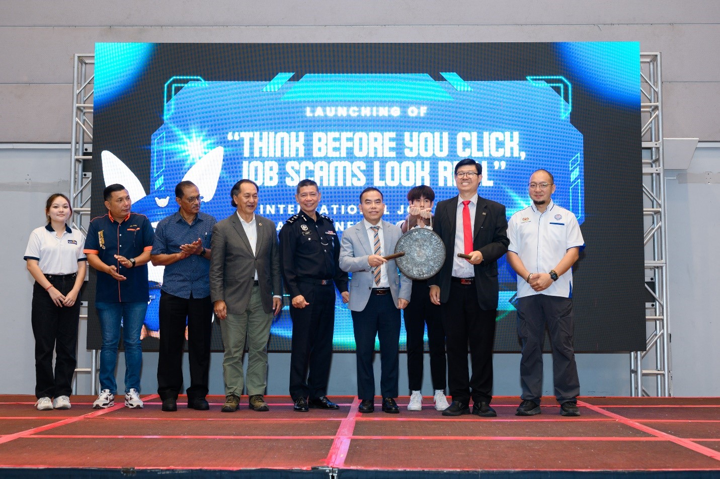 The International Job Scam Awareness Campaign was launched with a spirited gong; (from left) Revellyn Tan, Mr Joe Chan, Dr Sebastian, Dato’ Zainal Azman, SAC Luqman, Police Senior Lieutenant Colonel Nguyen, Prof Choong (second from right), and Mr Chung
