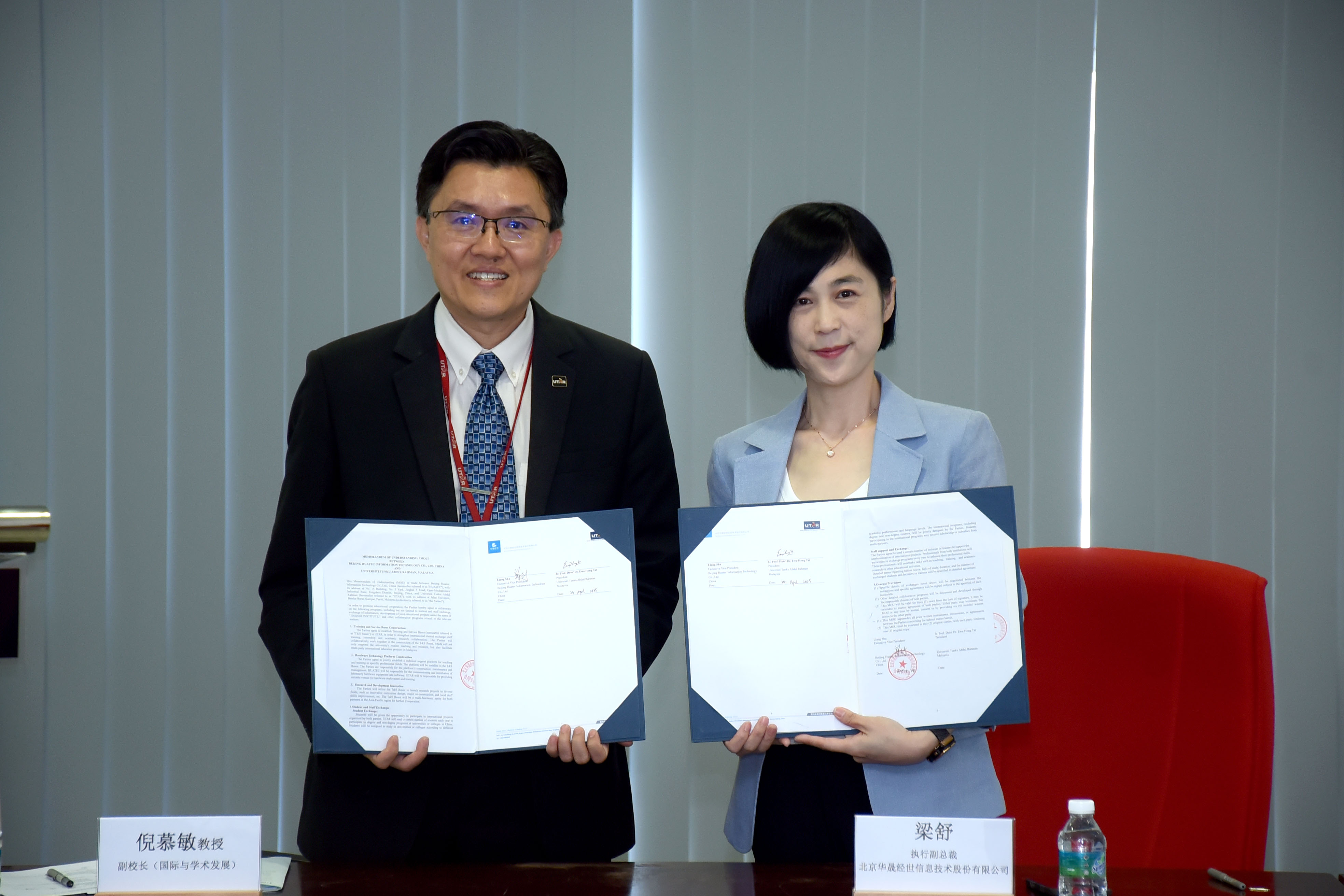 Prof Goi (left) and Ms Liang exchanging the MoU document
