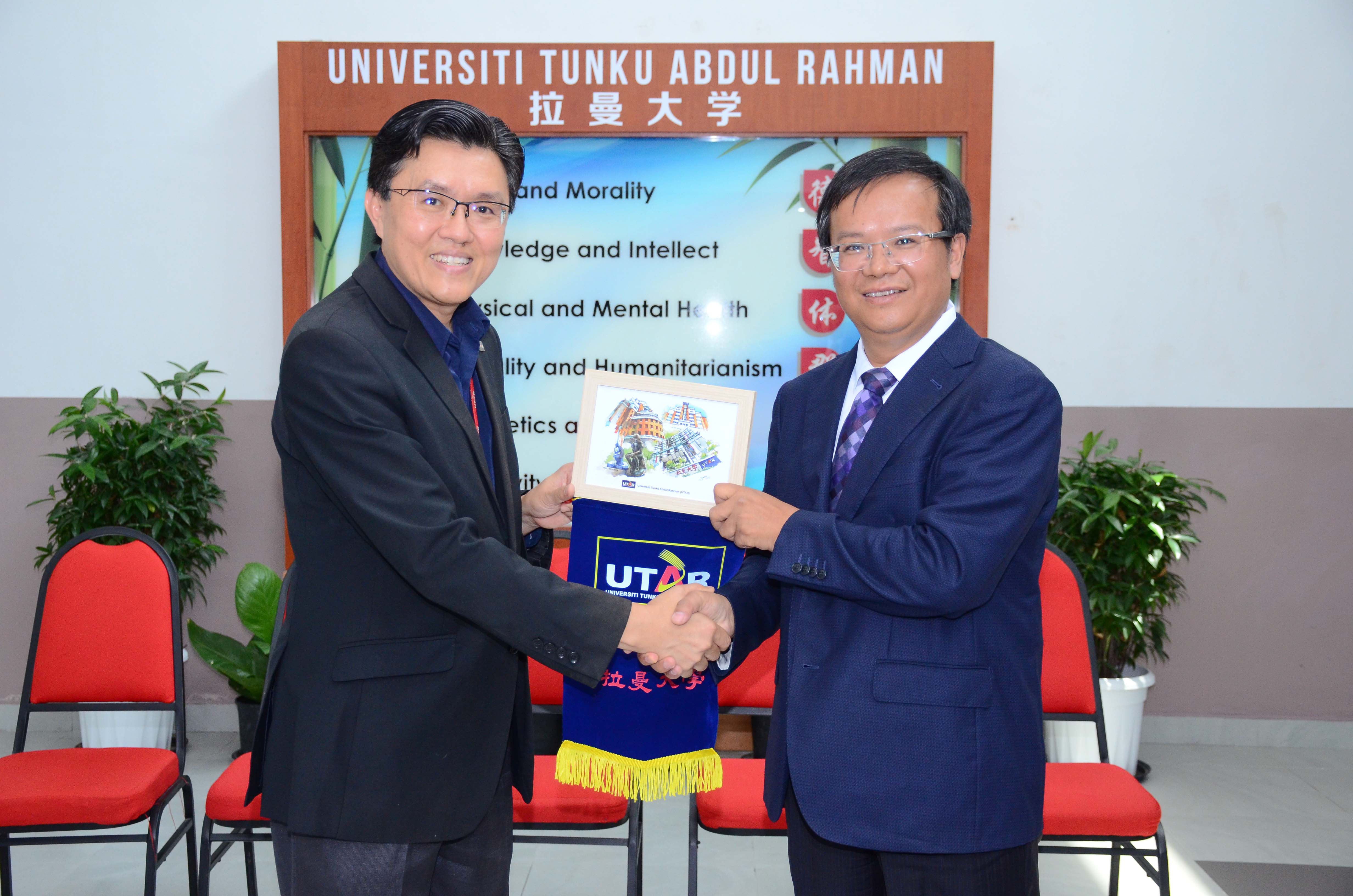 Prof Goi (left) presenting a token of appreciation to Prof Tian