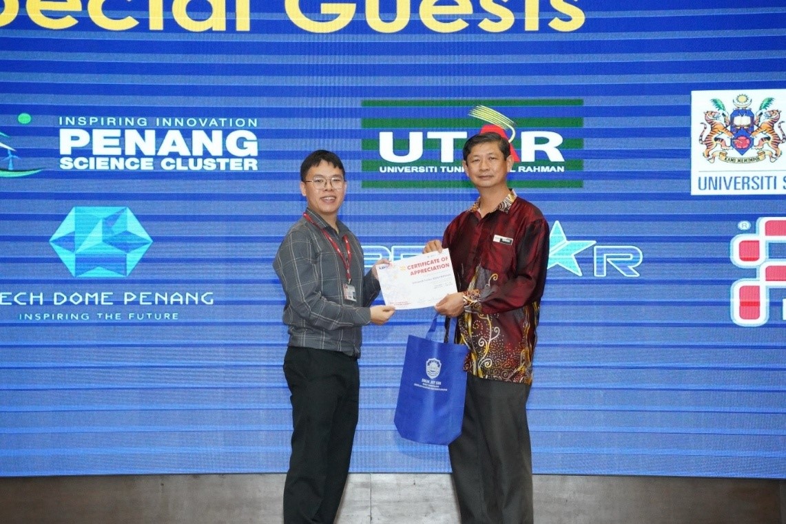 Dr Chin (left) receiving a certificate of appreciation and a souvenir from SMJK Jit Sin Principal Mr Gnoh Kam Fat