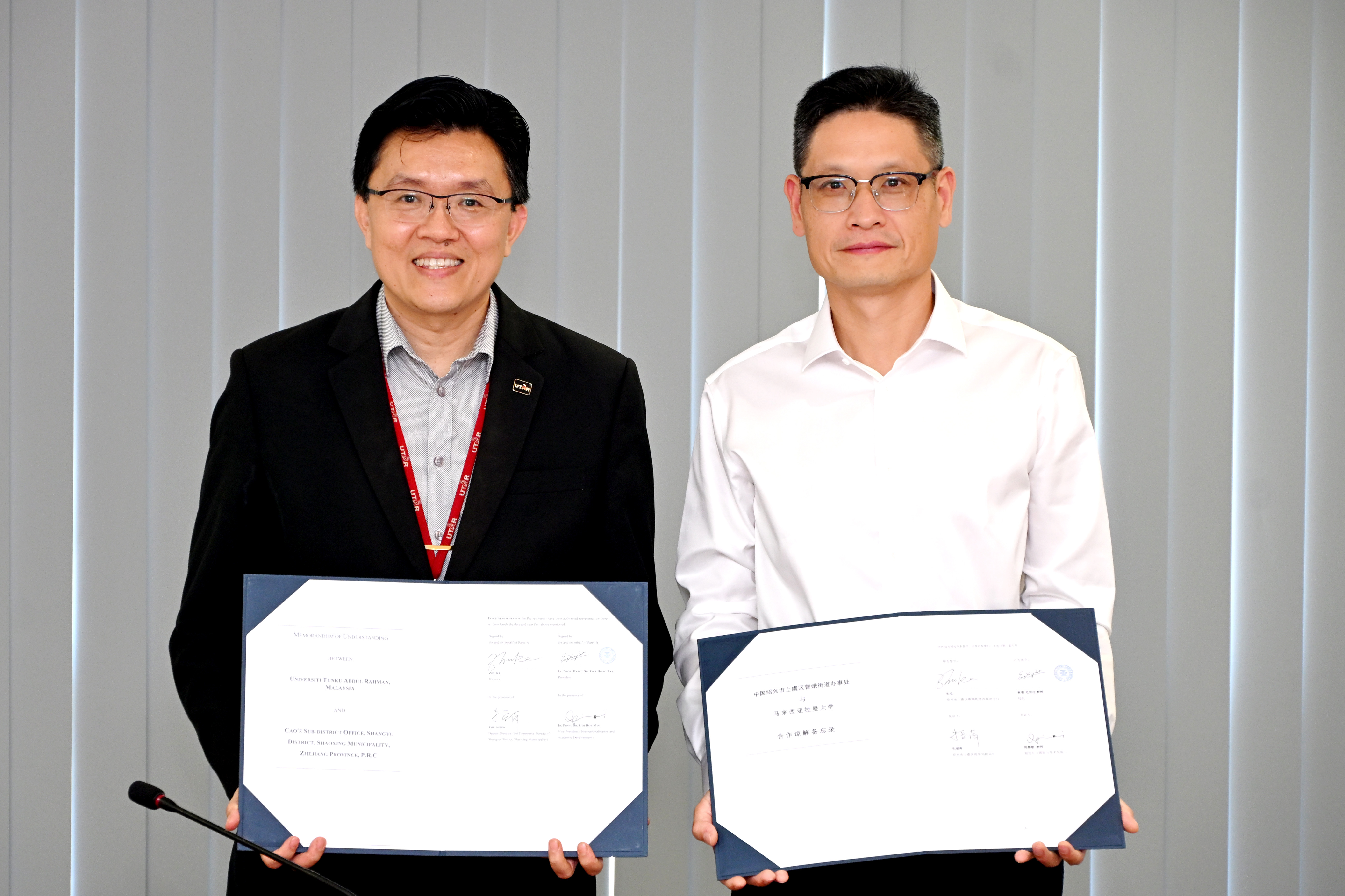 Prof Goi (left) and Mr Zhu displaying the signed document