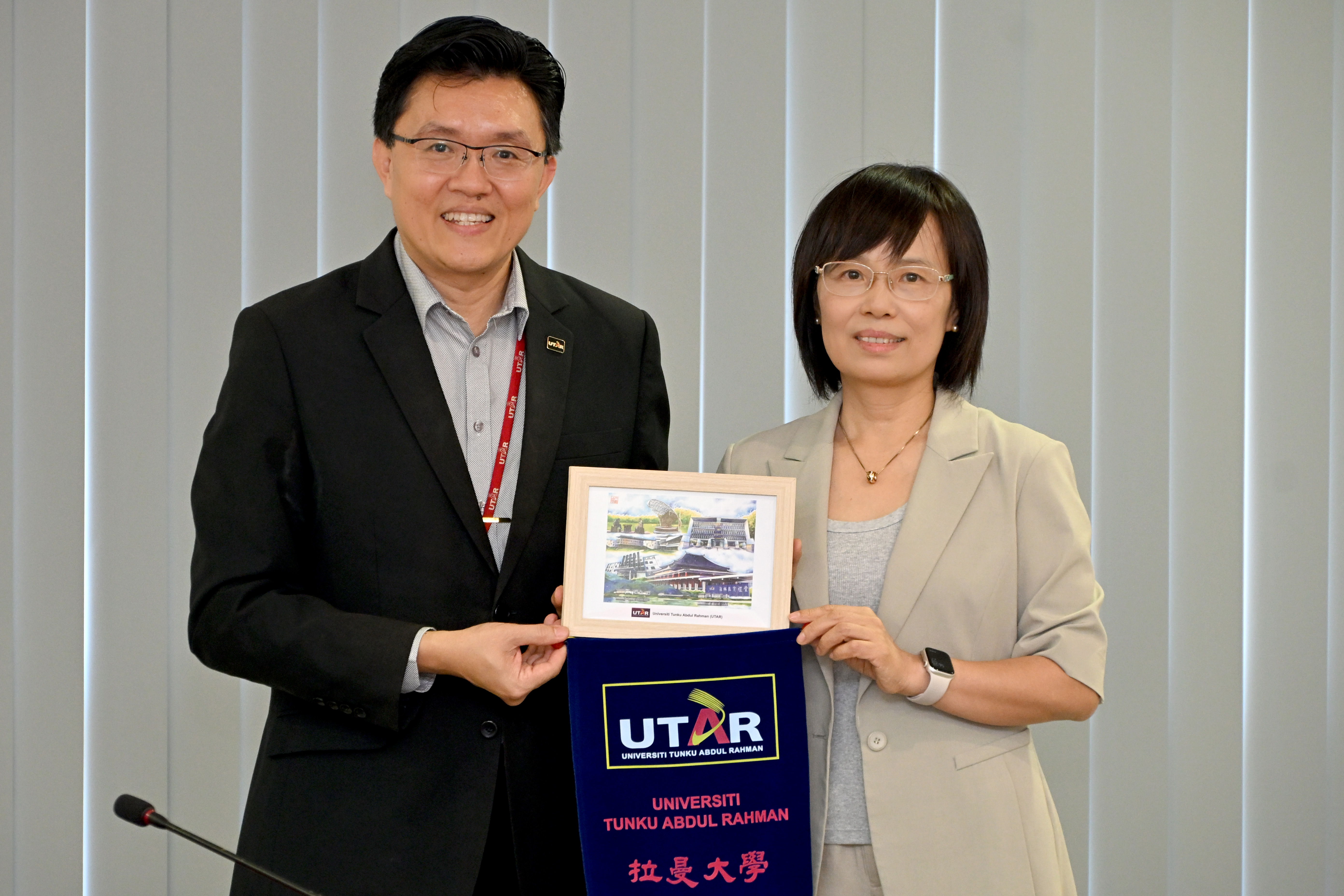 Prof Goi presenting souvenirs to Ms Zhang