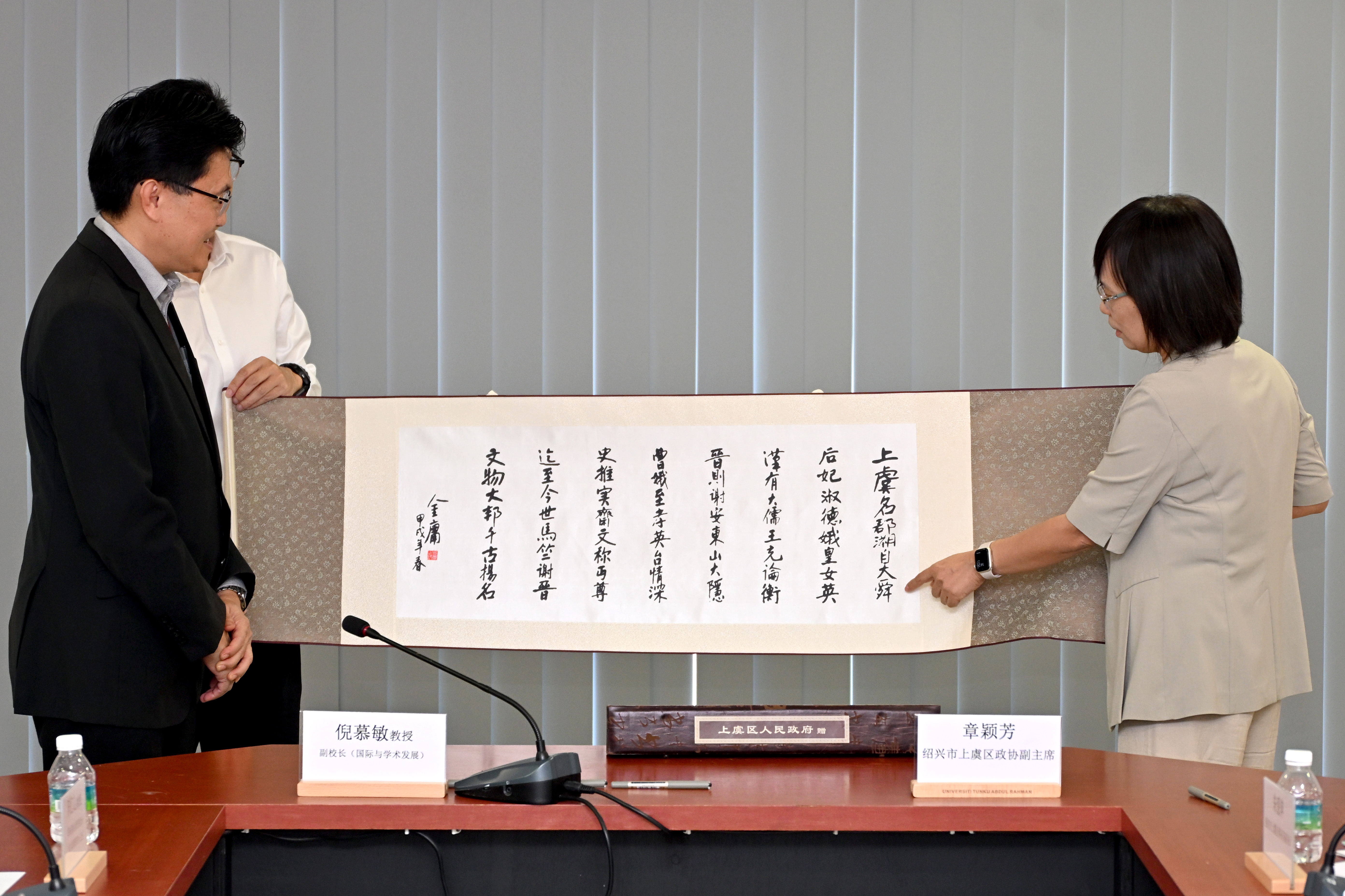 Ms Zhang sharing a poem written by Jin Yong about Shangyu, which she presented as a gift to UTAR