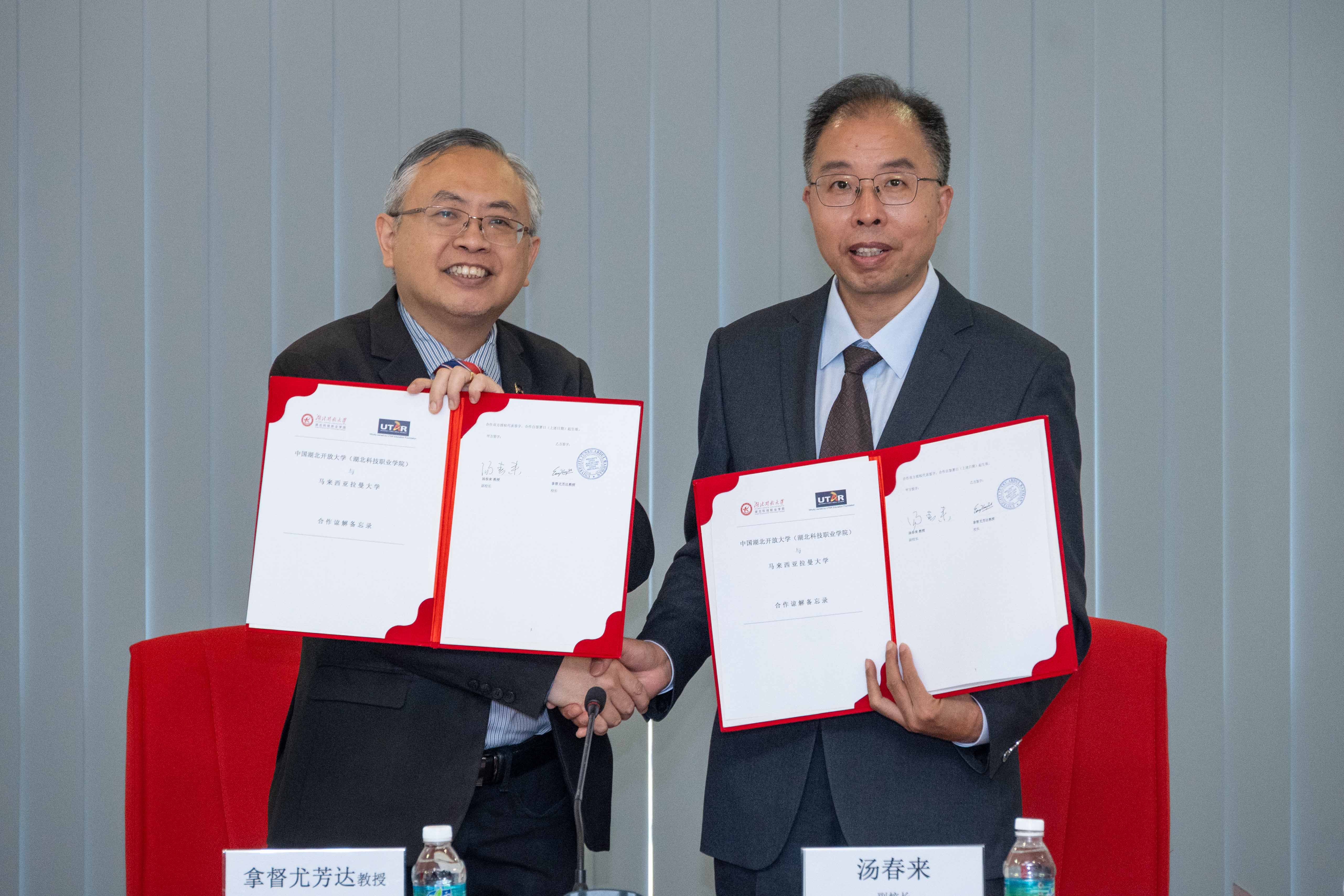 Prof Dato’ Ewe (left) and Prof Tang exchanging the MoU 