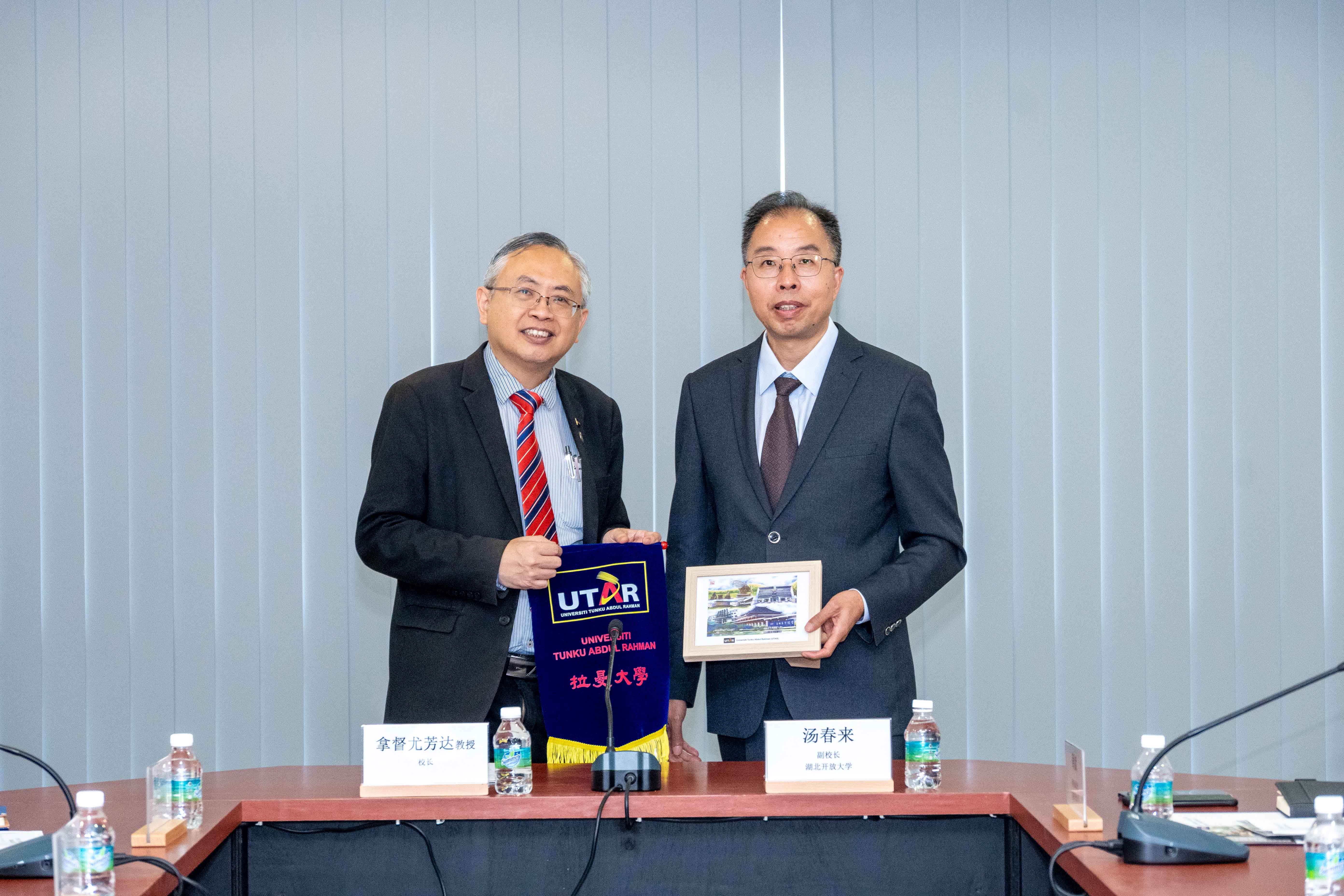 Prof Dato’ Ewe (left) and Prof Tang exchanging souvenirs as a symbol of goodwill