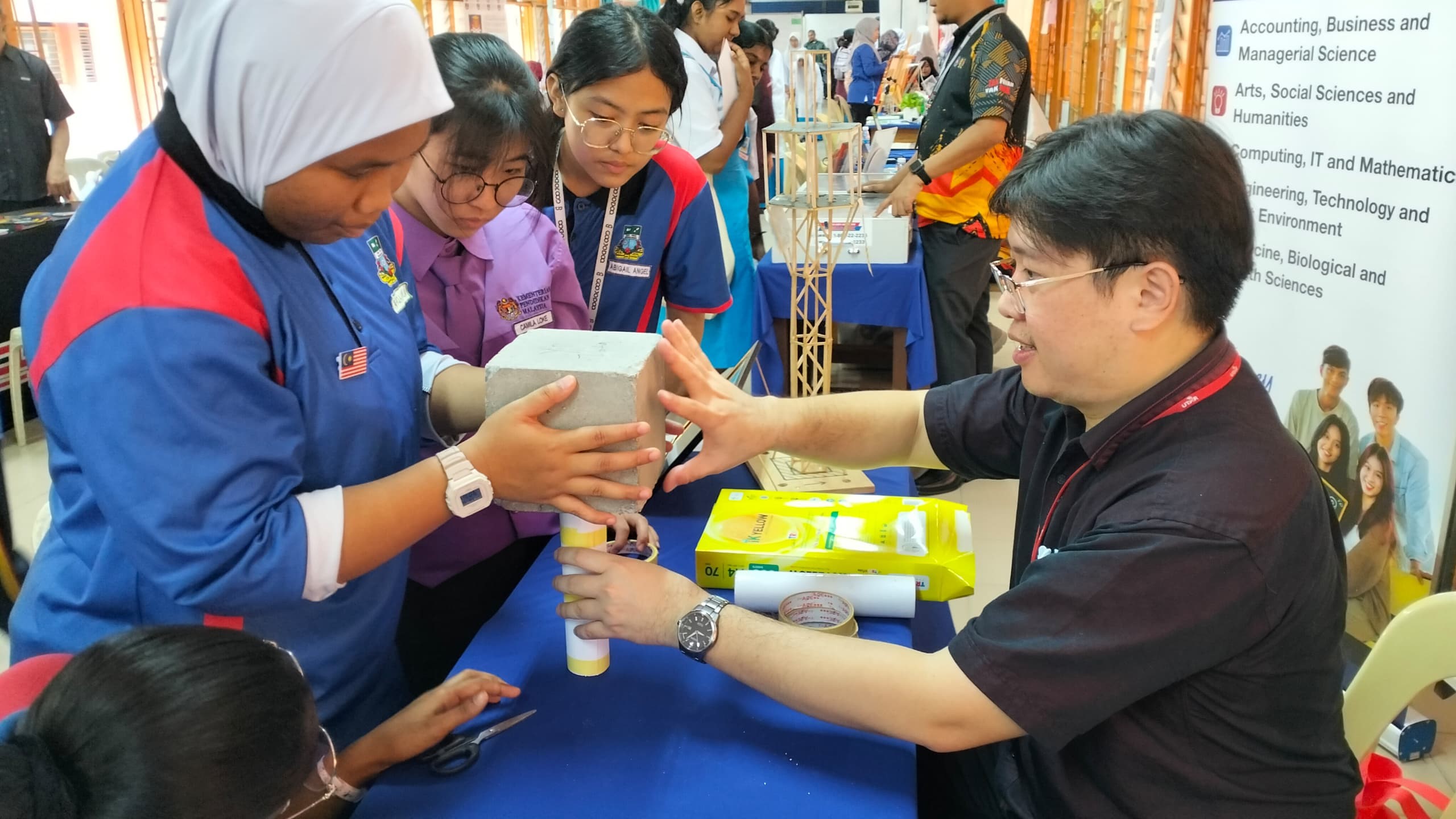 Students testing paper column with Ir Ts Dr Yip Chun Chieh