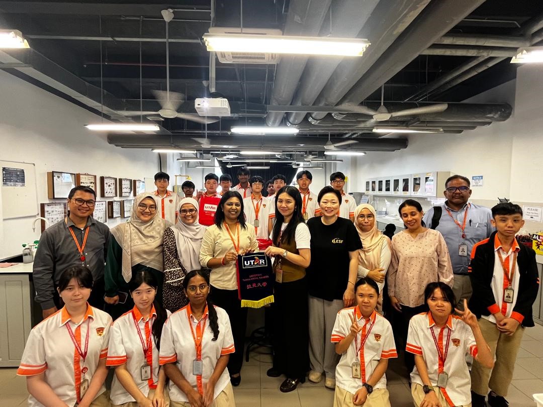 Dr Amelia (standing, fifth from left) presenting a token of appreciation to Rafflesia International School principal Ms Rasamah