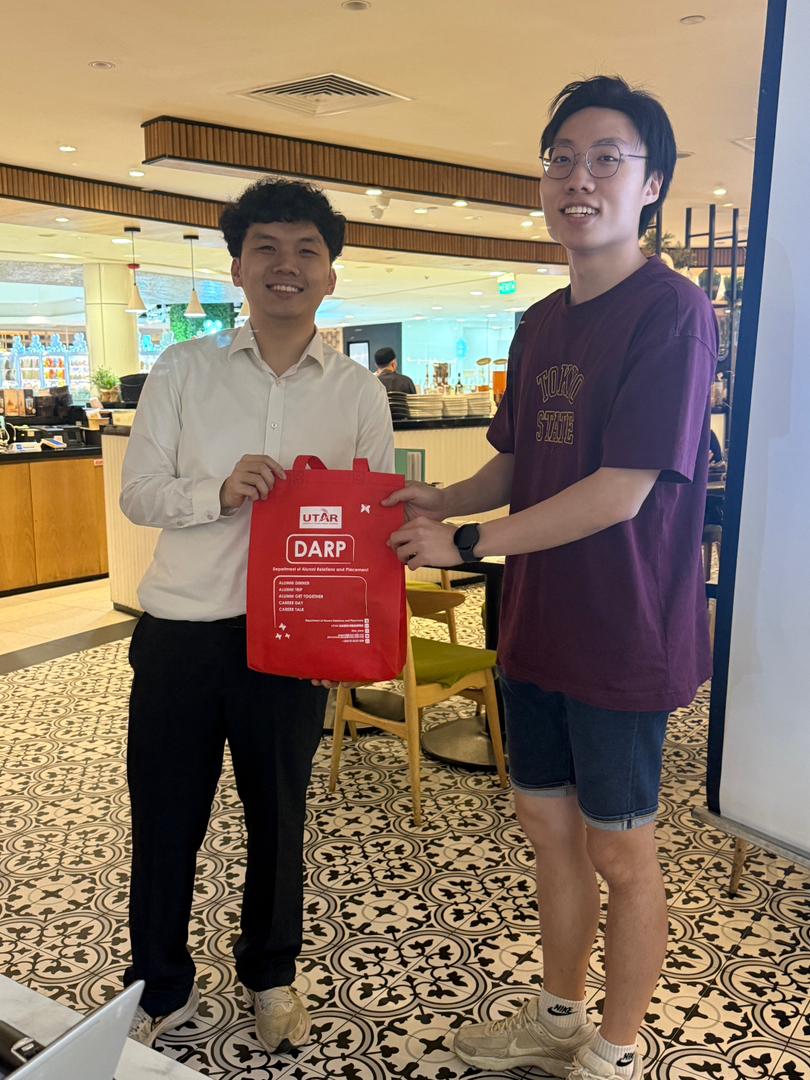 Mr Sia (left) presenting gifts to the lucky draw winners